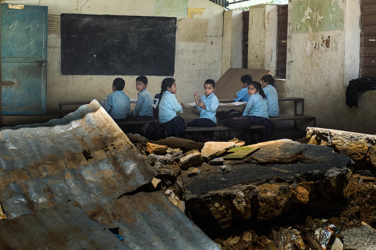 Students attend classes inside earthquake-damaged school buildings on 10 August 2015 in Sipa Pokhari. 