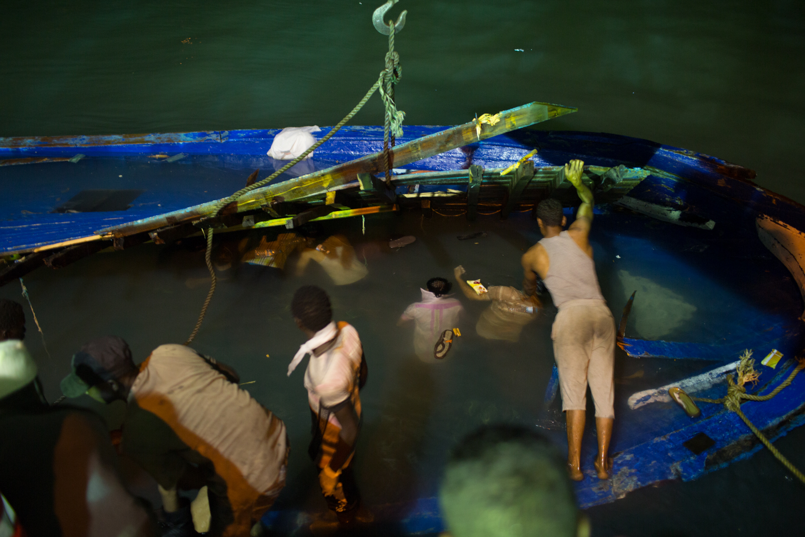 As the boat was towed into port, the grim task of removing trapped bodies began
