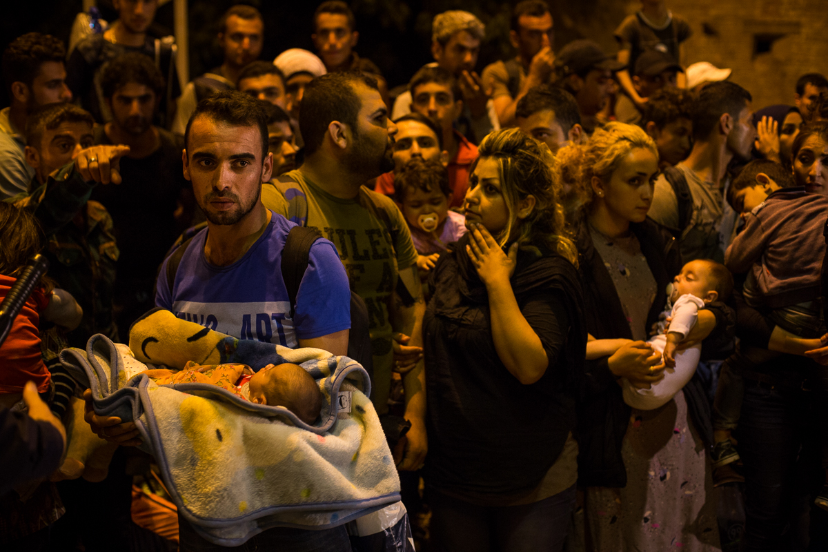 Another crowd of refugees forms on the train tracks in Tovarnik, where many wait more than 24 hours for a train to take them north. 