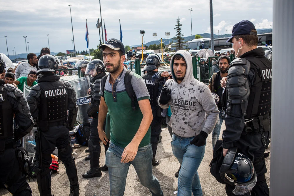 Having made it past the border check, refugees walk towards a bus they have been told will take them all the way to Slovenia's border with Austria.
