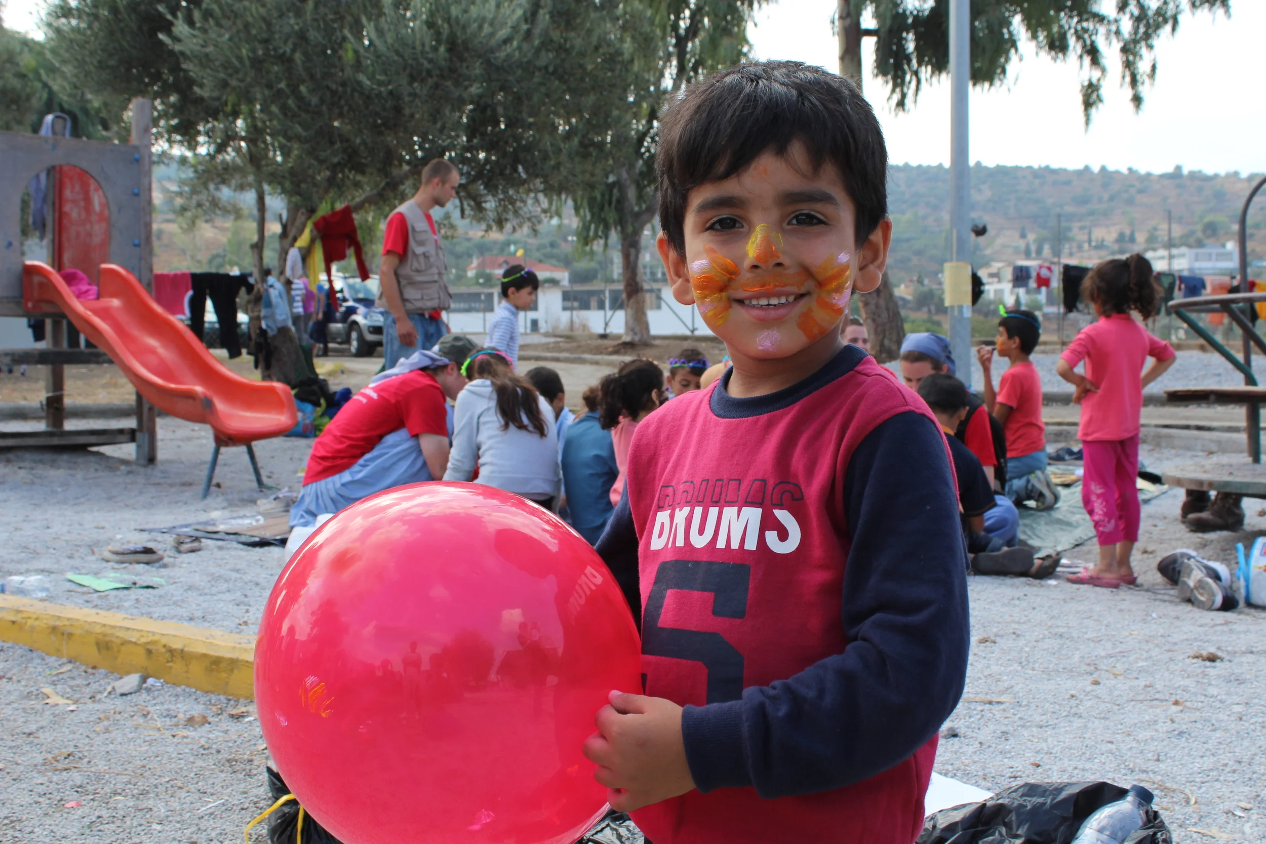 A child plays with a balloon in one of Save the Children's Child Friendly Spaces in Kara Tepe camp, where facepainting is also available for children while their parents wait in line. There are no Child Friendly Spaces in Moria (Daniel Elkan/IRIN)