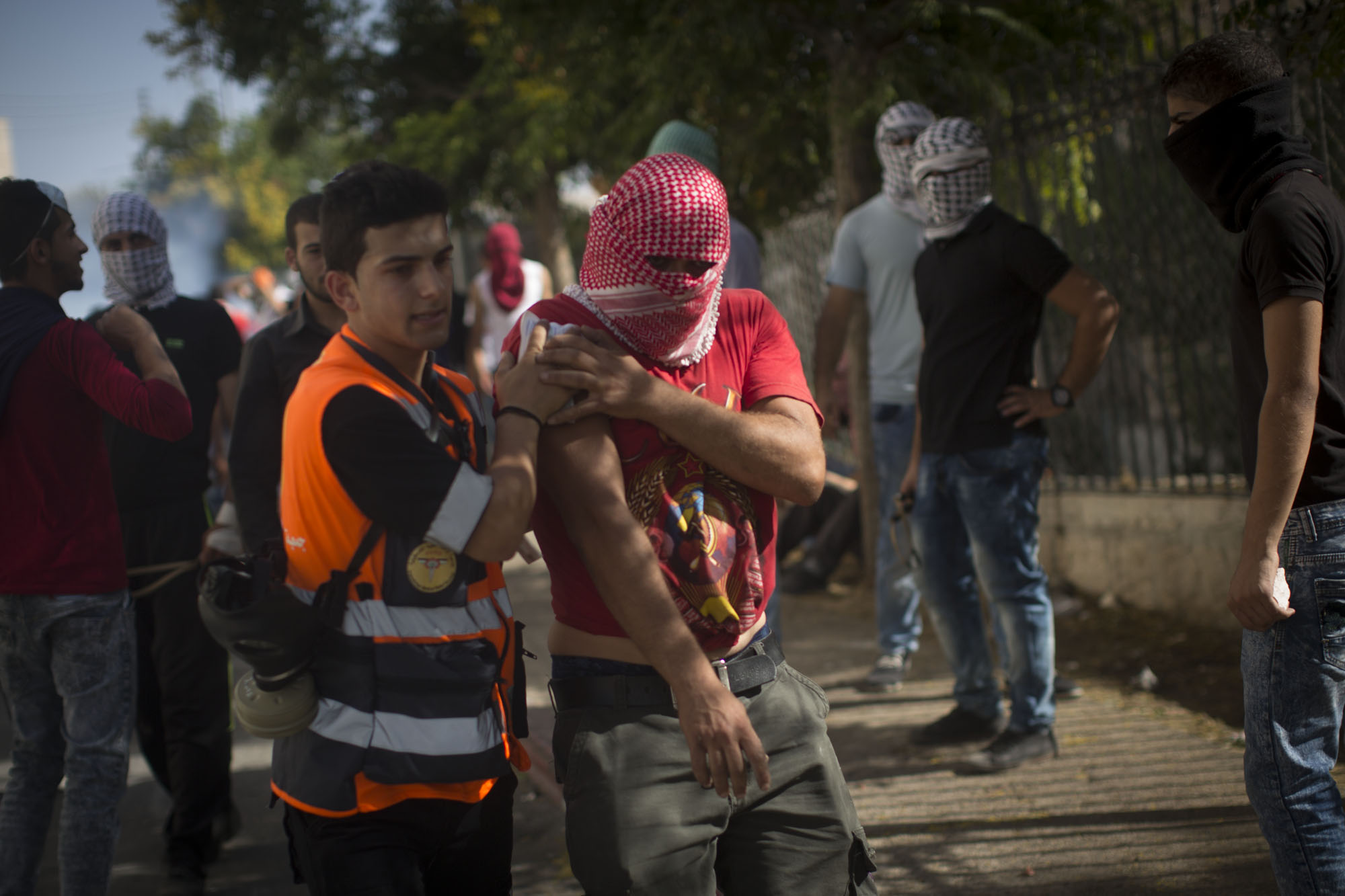 A first responder from the Palestinian Medical Relief Society - a separate organization from the PRCS - tends to the wounded during a Bethlehem skirmish. Clashes with the Israeli army in the West Bank have left many injured by rubber bullets and tear gas
