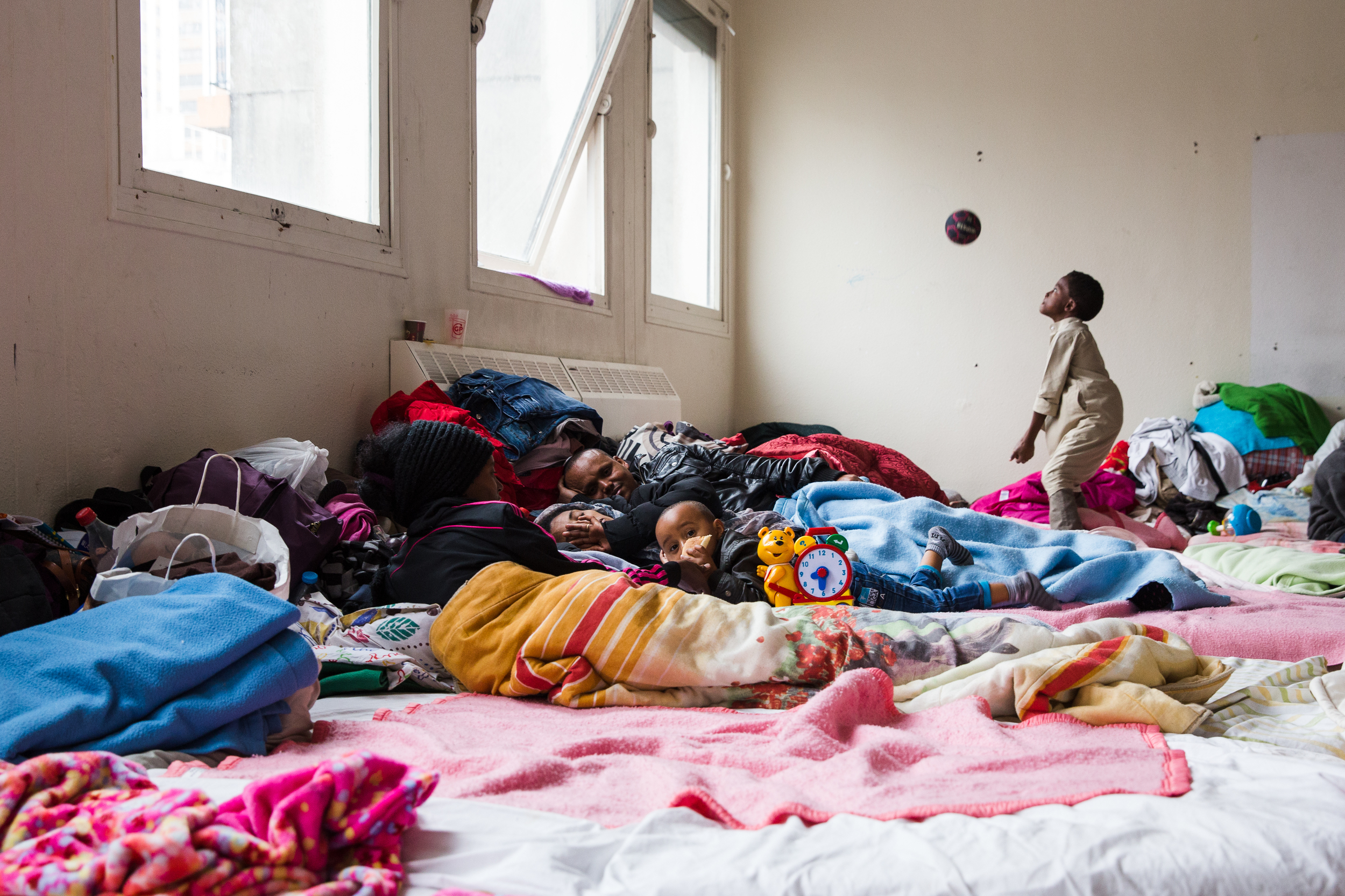   Kiflom watches over his wife, who suffers from headaches and has stopped eating. Conditions here seem to help spread disease. This is one of the few families living here: most residents are single young men.  