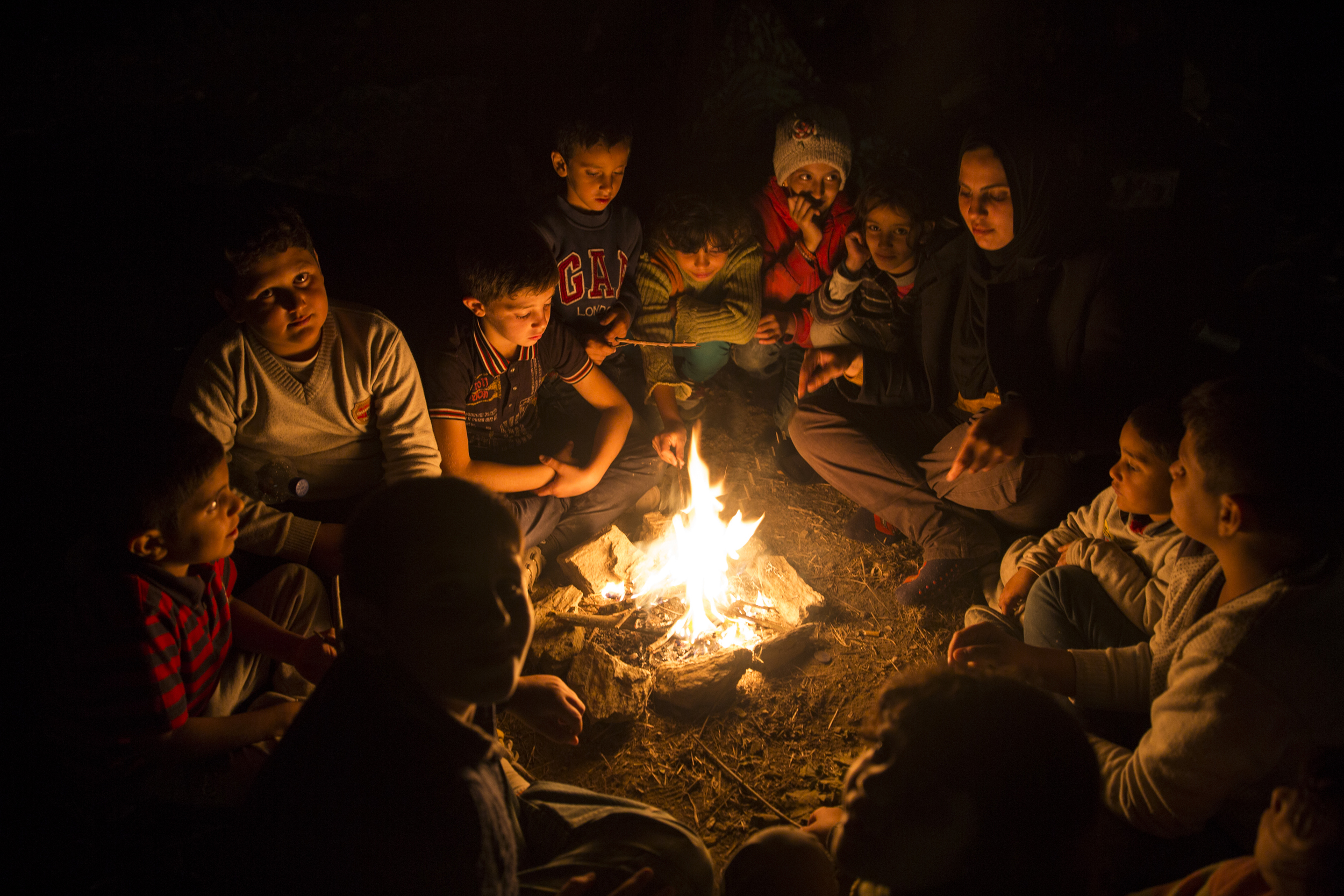   Children gathered around a fire in the olive groves outside Moria where hundreds have been camping in recent days while they wait to be registered  