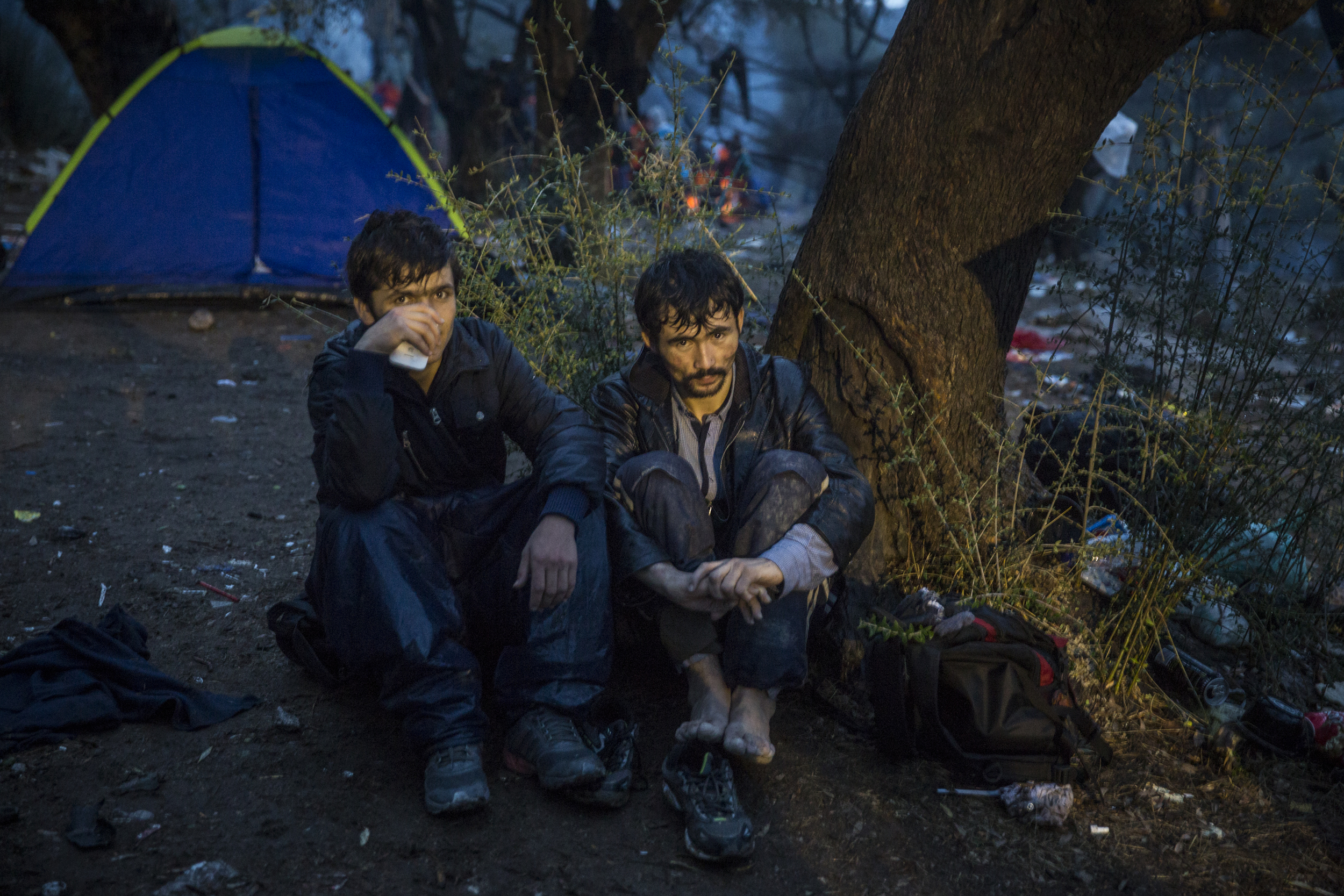   Two Afghan refugees camp in the rain outside Moria  