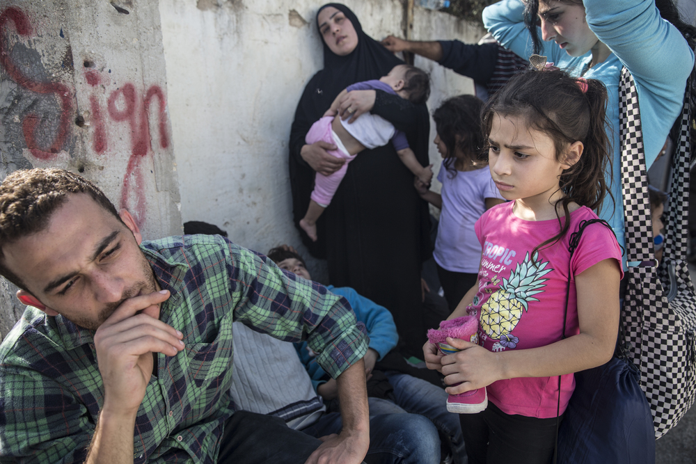   Alla Abdo(à gauche) avec sa cousine Jihan et leurs quatre enfants, à l’extérieur de Moria. M. Abdo affirme qu’ils sont Syriens mais qu’ils ont perdu leurs papiers. On ne les a pas autorisés à s’enregistrer à Kara Tepe, un centre d’enregistrement po