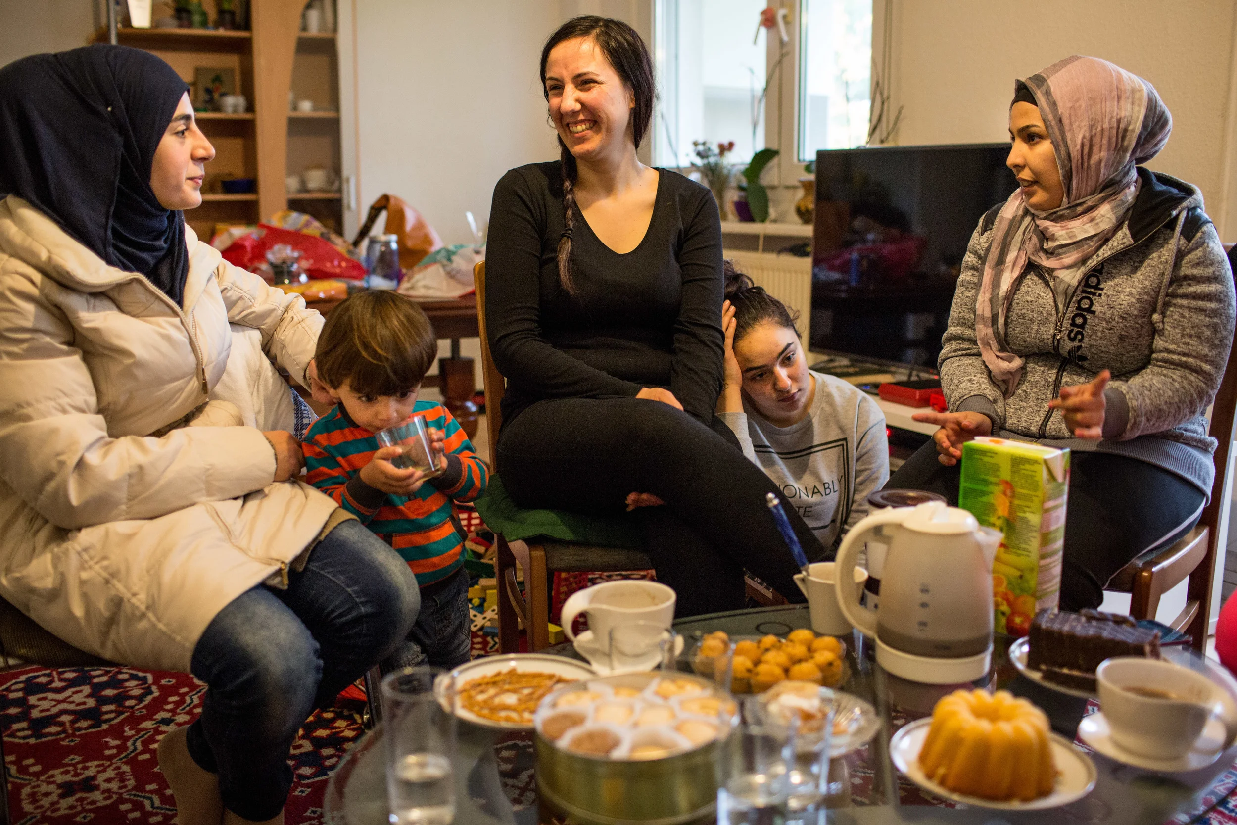 Neamat Kanaan (middle) and her daughter Sara host Syrian friends in their living room (Andrei Pungovschi/IRIN) 