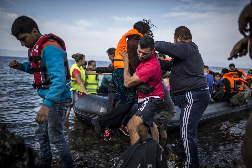 Salam Aldeen of volunteer group Team Humanity helps refugees disembark from a boat arriving on Lesvos (Jodi Hilton/IRIN)