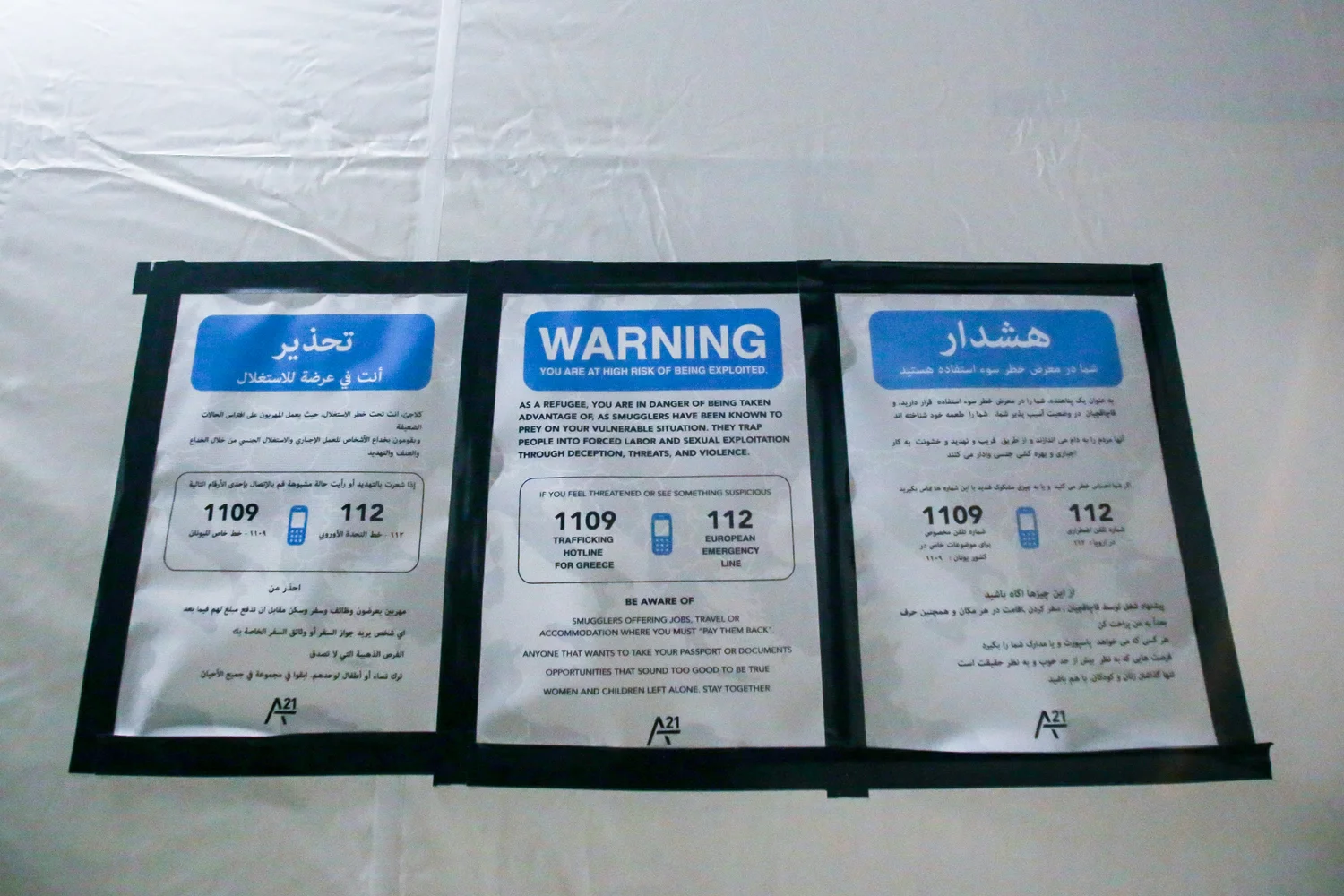 Devant une tente du camp de transit d’Idomeni, une affiche avertit les réfugiés du danger de recourir à des passeurs et donne un numéro d’assistance téléphonique pour dénoncer leurs activités