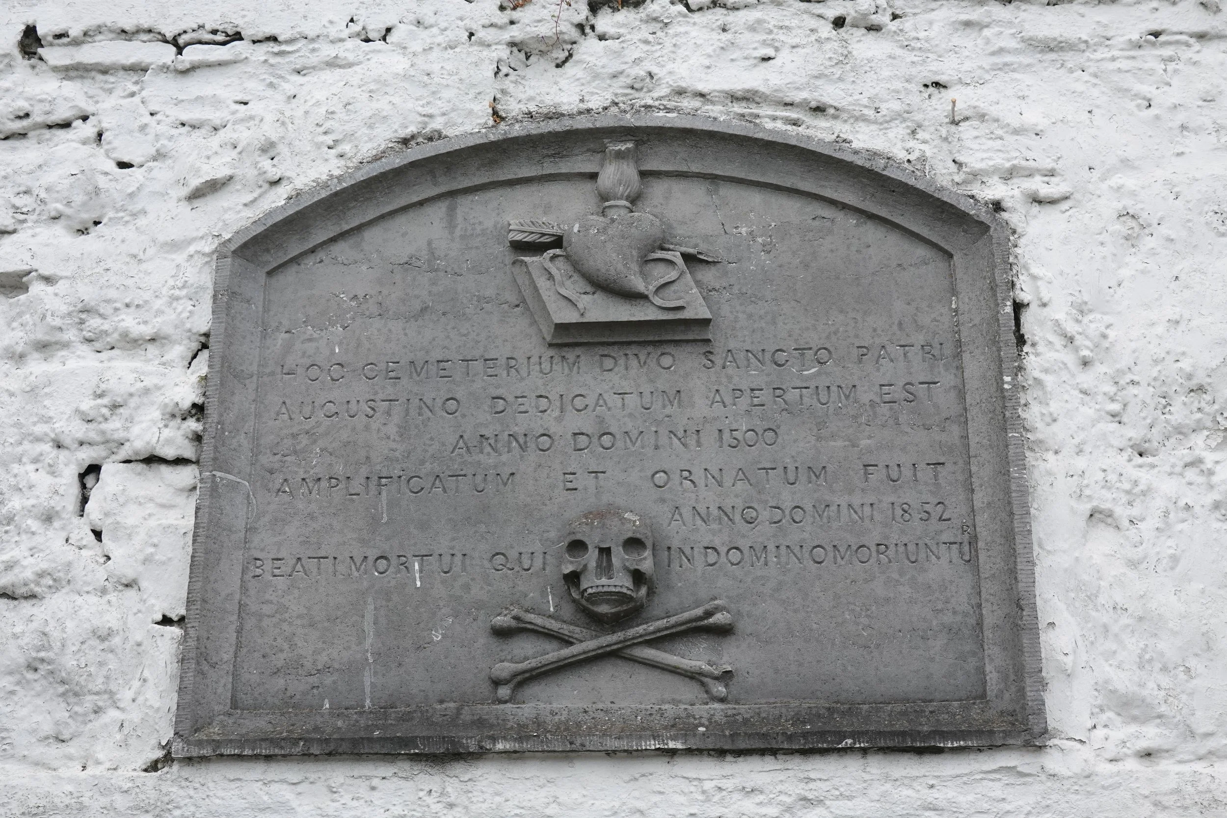 gravestone with a heart at the top and a skull and crossbones at the bottom