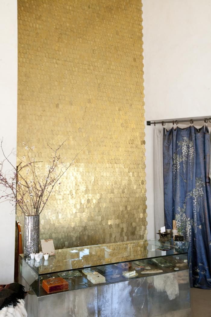 Gold Backsplash on a white wall at a Clothing Store provides interesting reflection depending on the time of the day