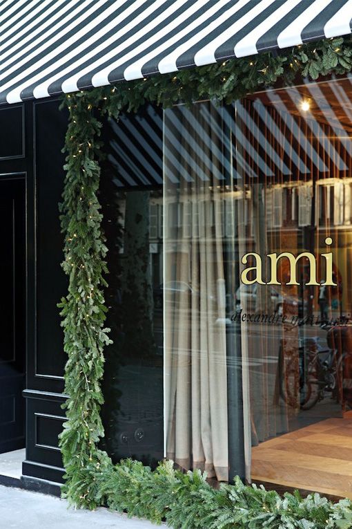 Ami Storefront; Garland Wreath and lights surround the entire glass storefront window. Elegant and Timeless
