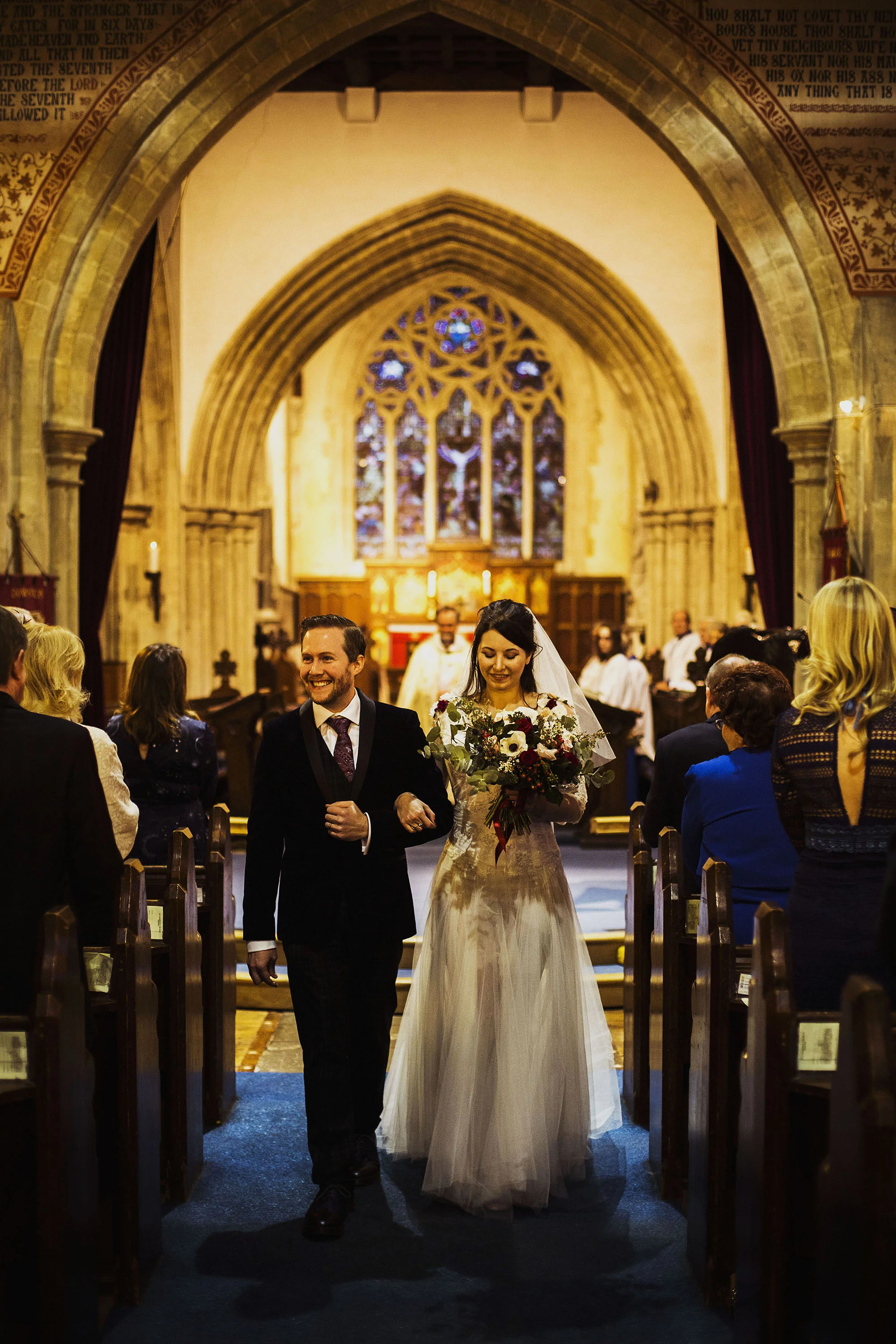 bride and groom walking down the isle at st laurence church
