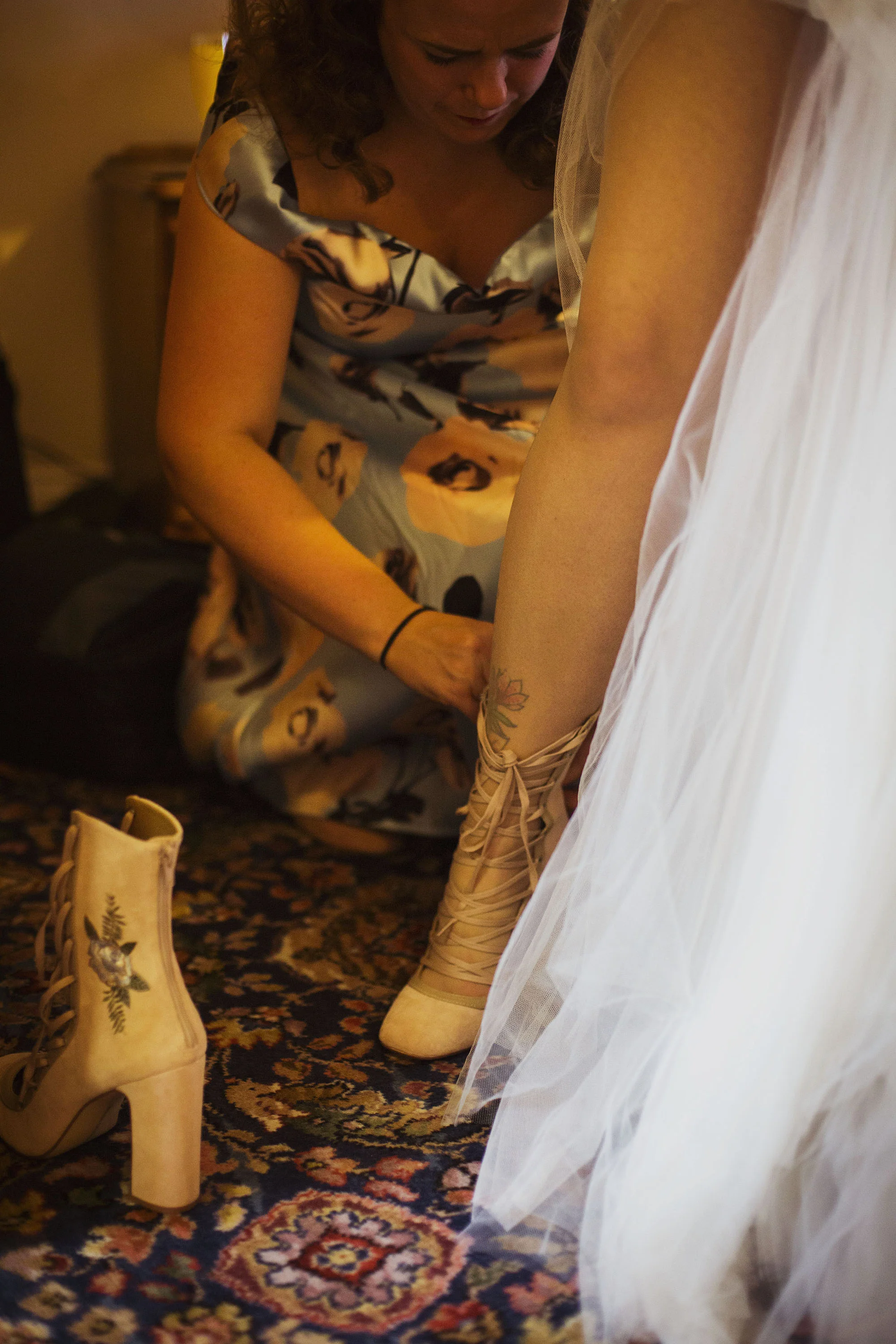 bridesmaid helping bride put her wedding shoes on at grasmere house hotel in salisbury