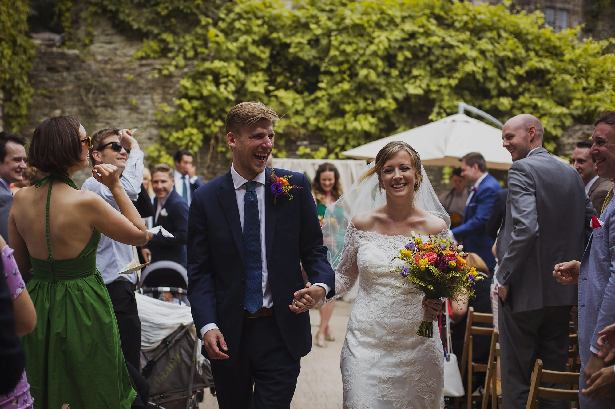 bride and groom smiling walking down the isle at usk castle