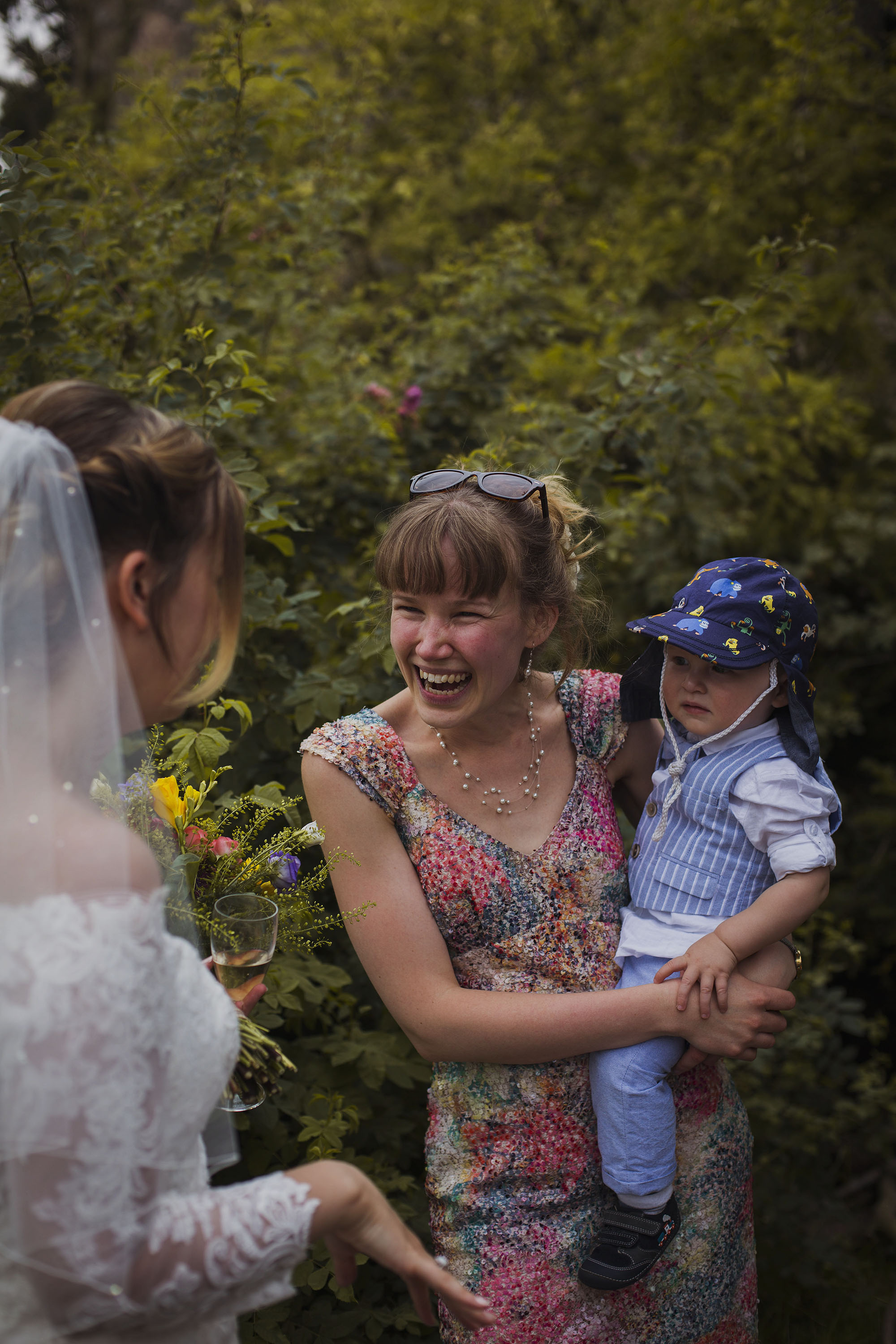 mother holding baby boy smiling with the bride at wedding at usk castle
