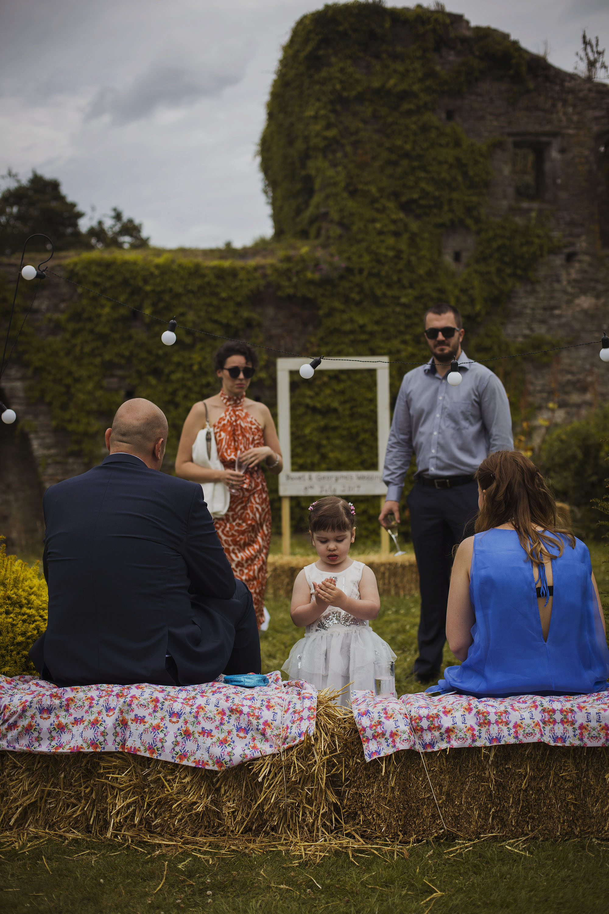 wedding guests sitting on hay bales at usk castle
