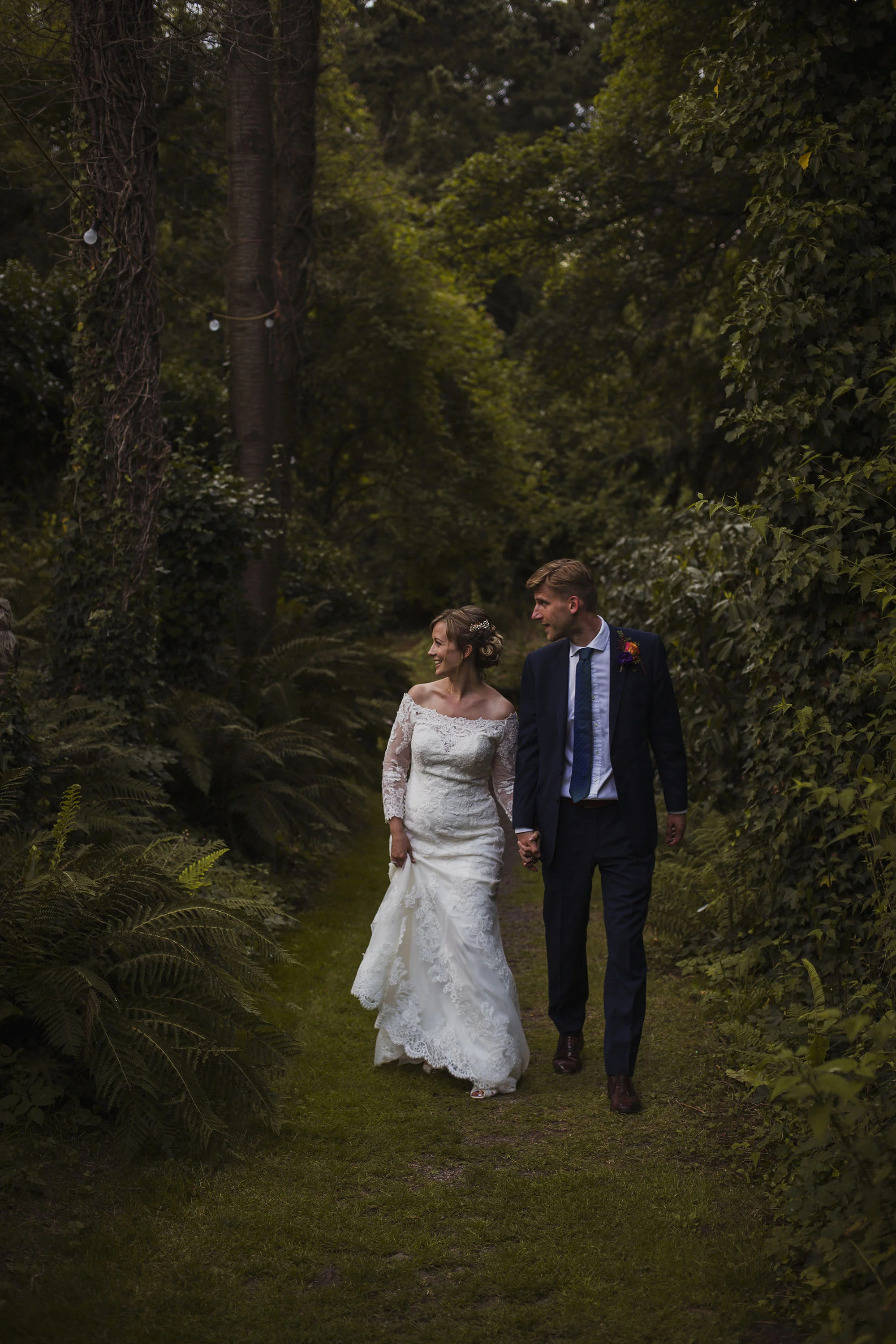 bride and groom portrait walking together at usk castle