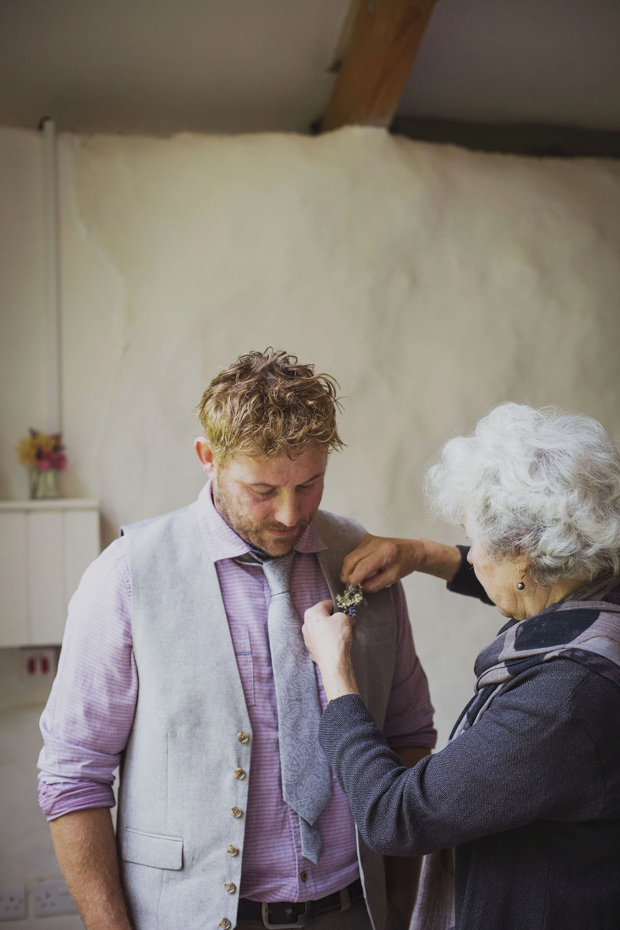 groom and groom's mother attaching button hole at nantwen wedding venue