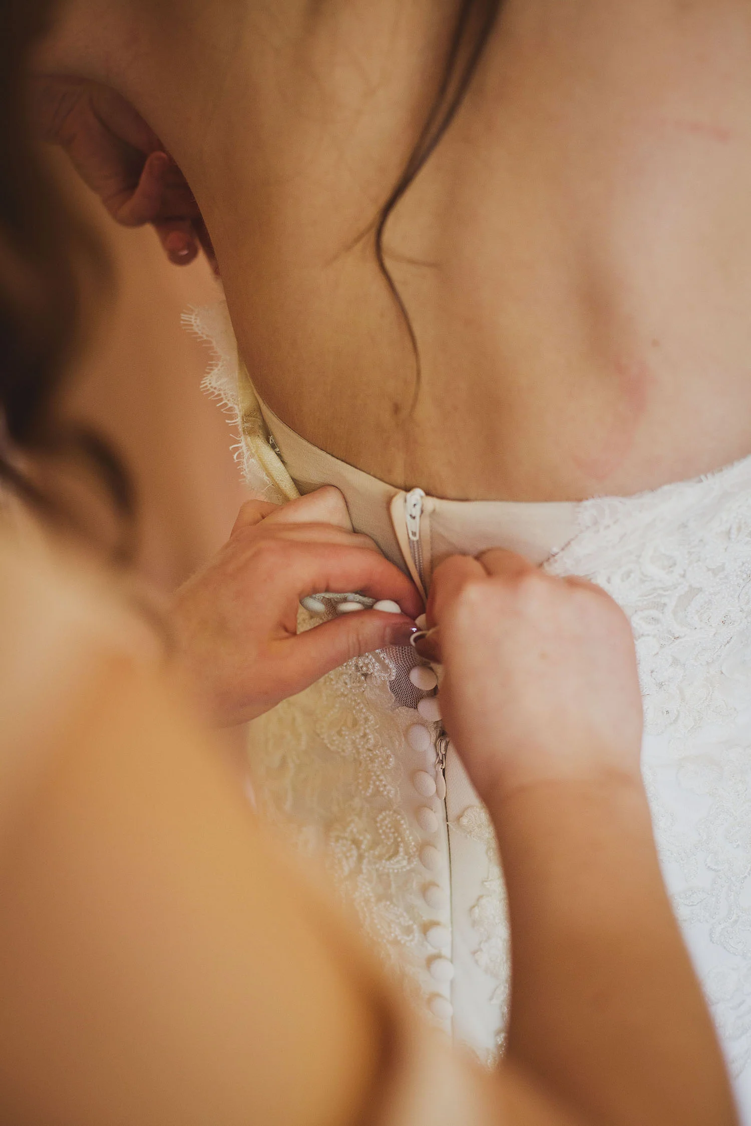 bride's dress being buttoned up somerset wedding