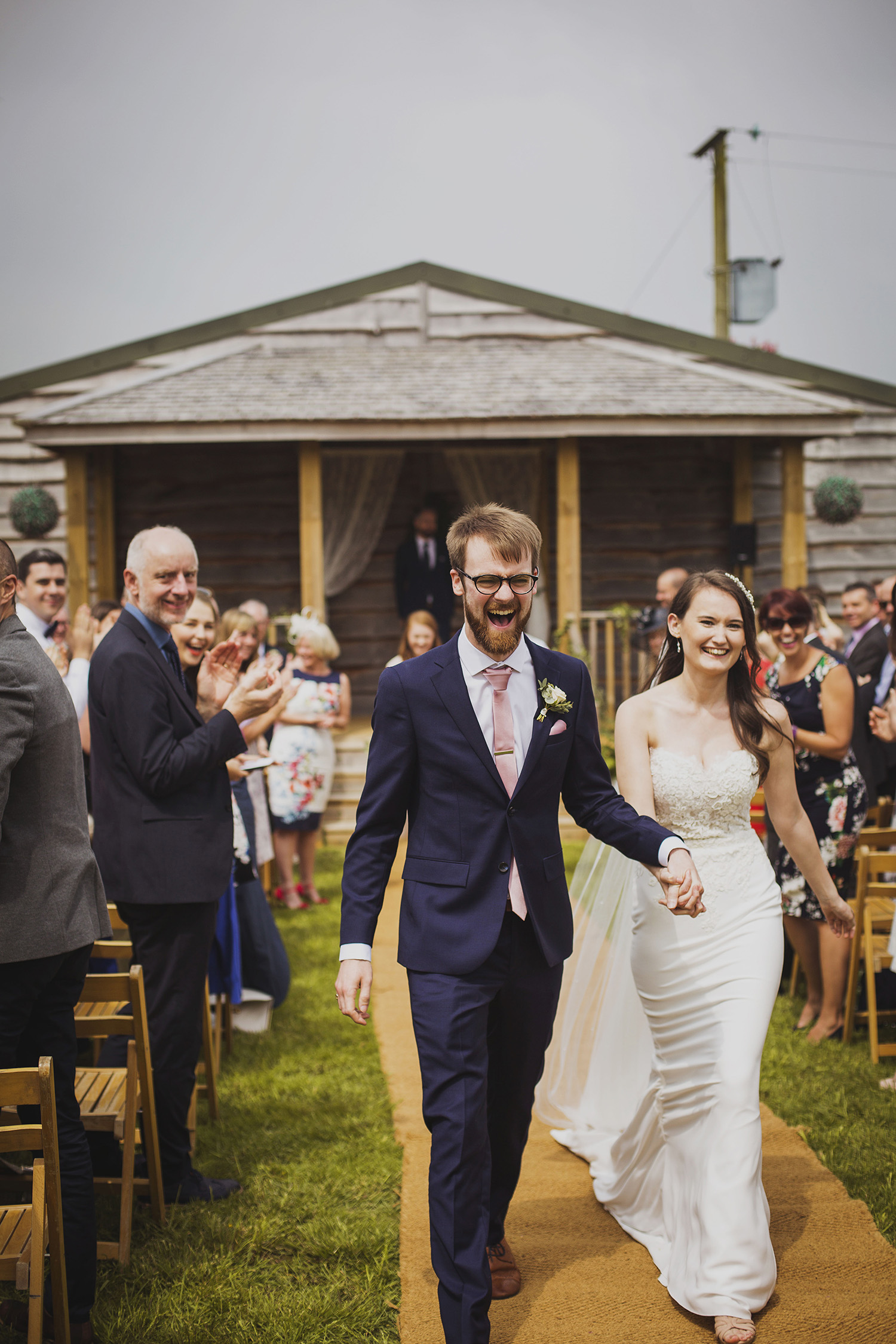 bride and groom walking down the isle at wedding ceremony at cott farm barn wedding venue somerset