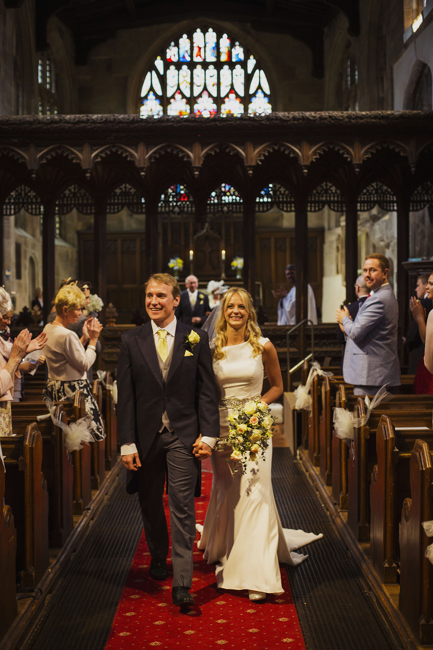 bride and groom walk down the isle at wedding ceremony at knowle parish church