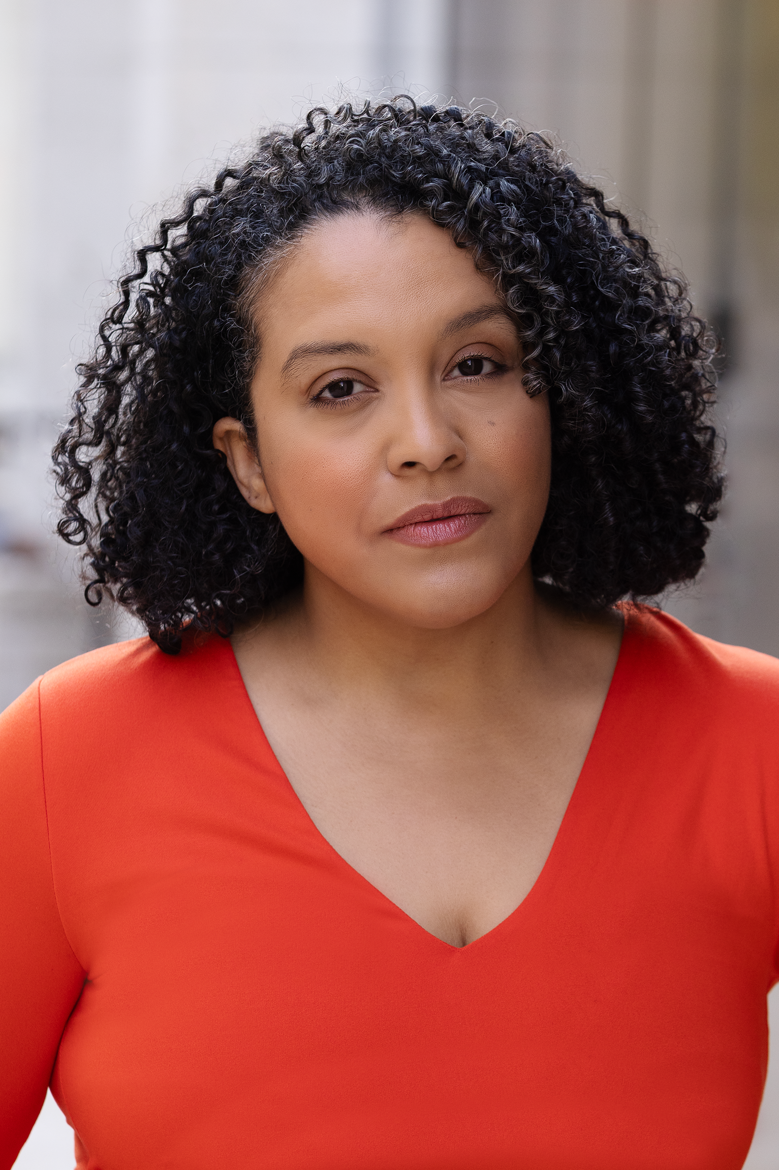 actress miriam morales, wearing a bright red orange top in NYC