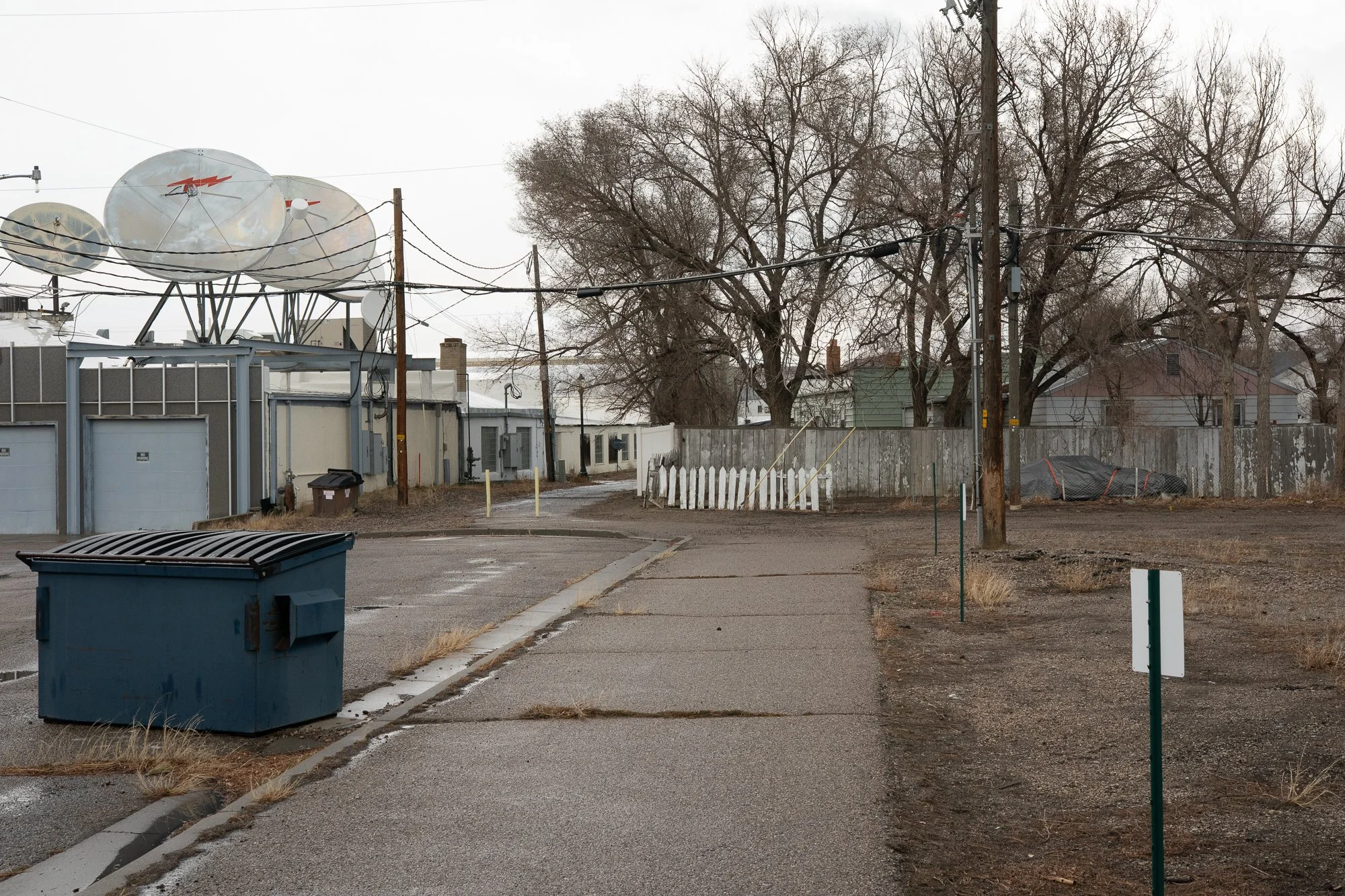 Satellite dishes and utility wires above a back street in Rock Springs Wyoming
