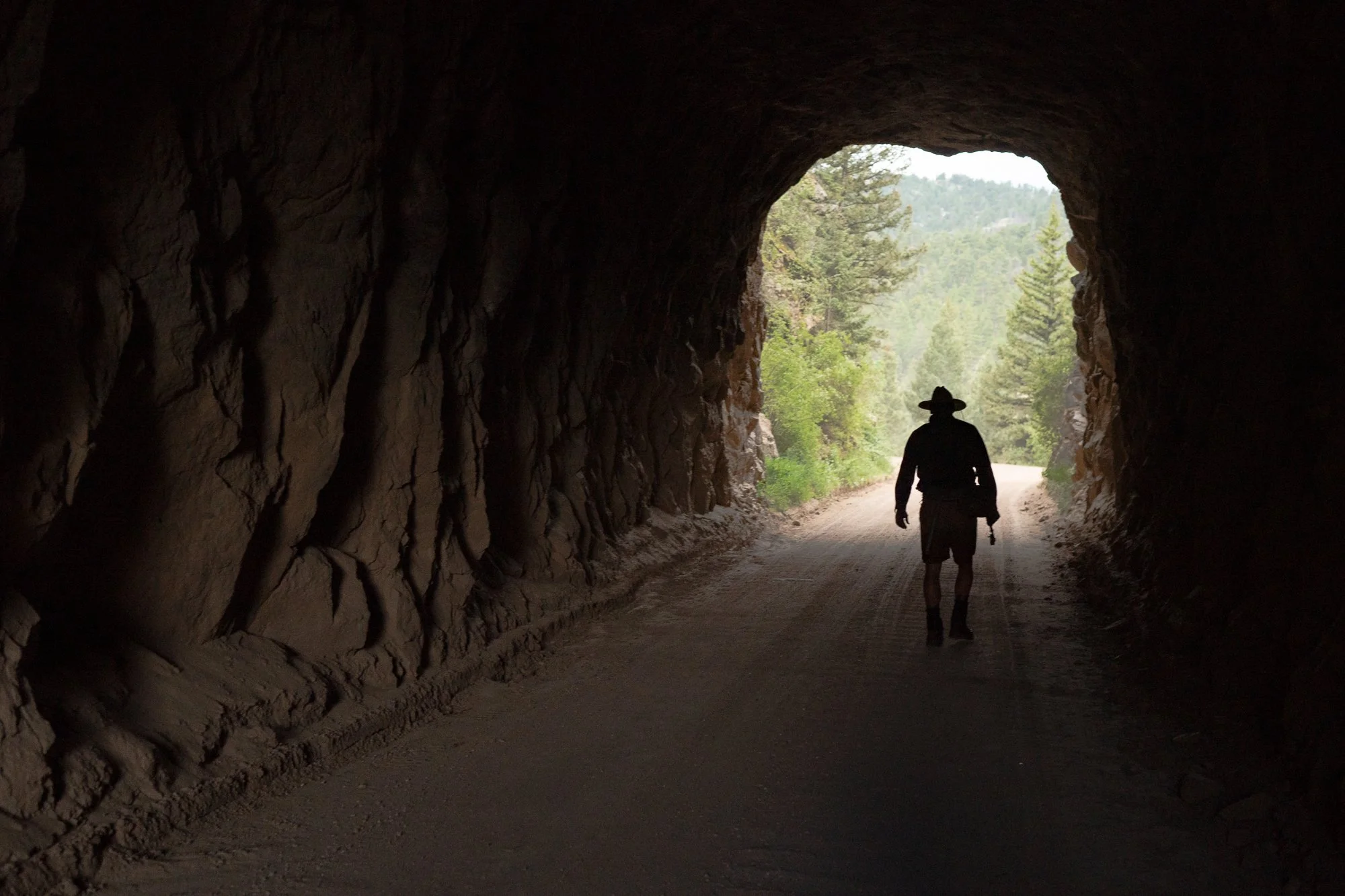 Photograph of a fly fisherman walking through a rock runnel in 11 Mile Canyon
