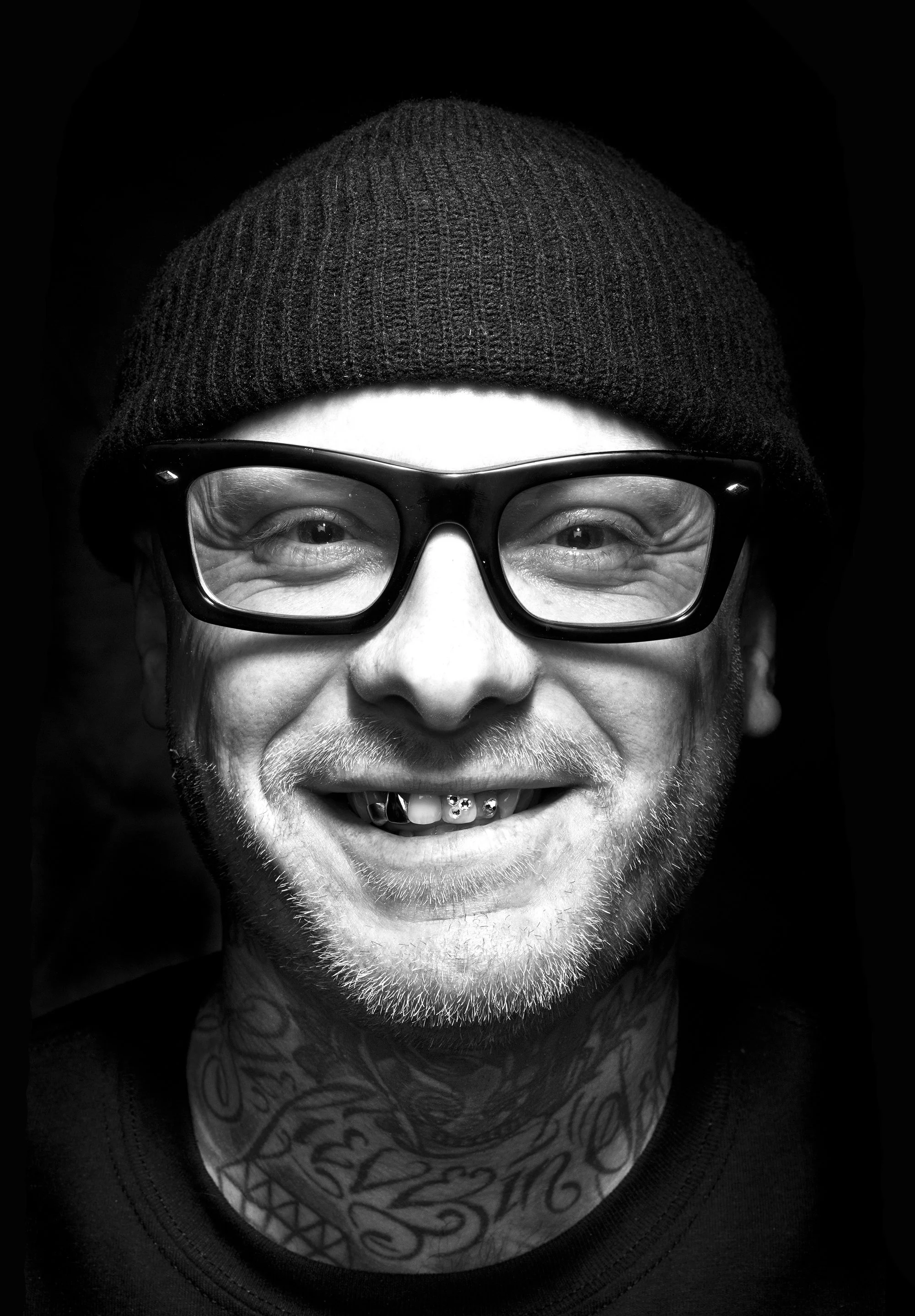 Black and white portrait of barber Shane Nesbitt wearing glasses and a beanie, San Mateo California