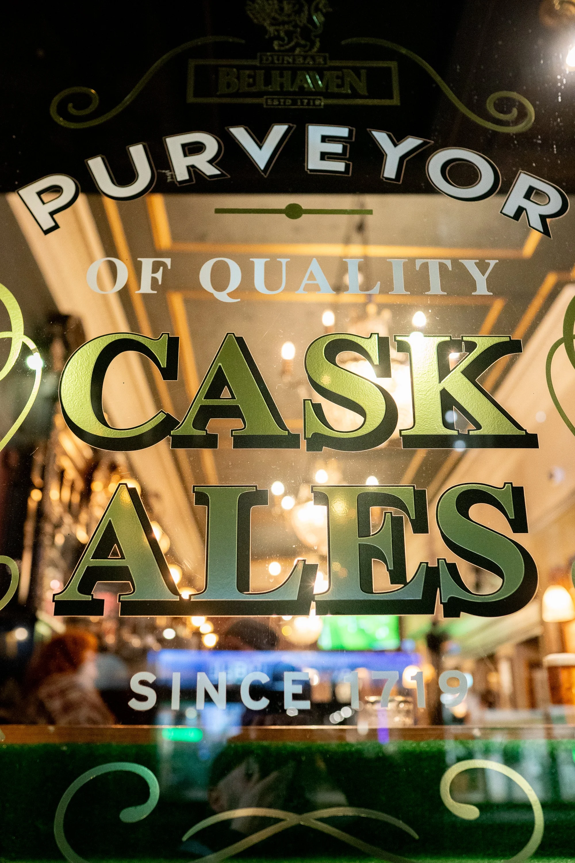 Window sign reading Purveyor of Quality Cask Ales inside Edinburgh pub