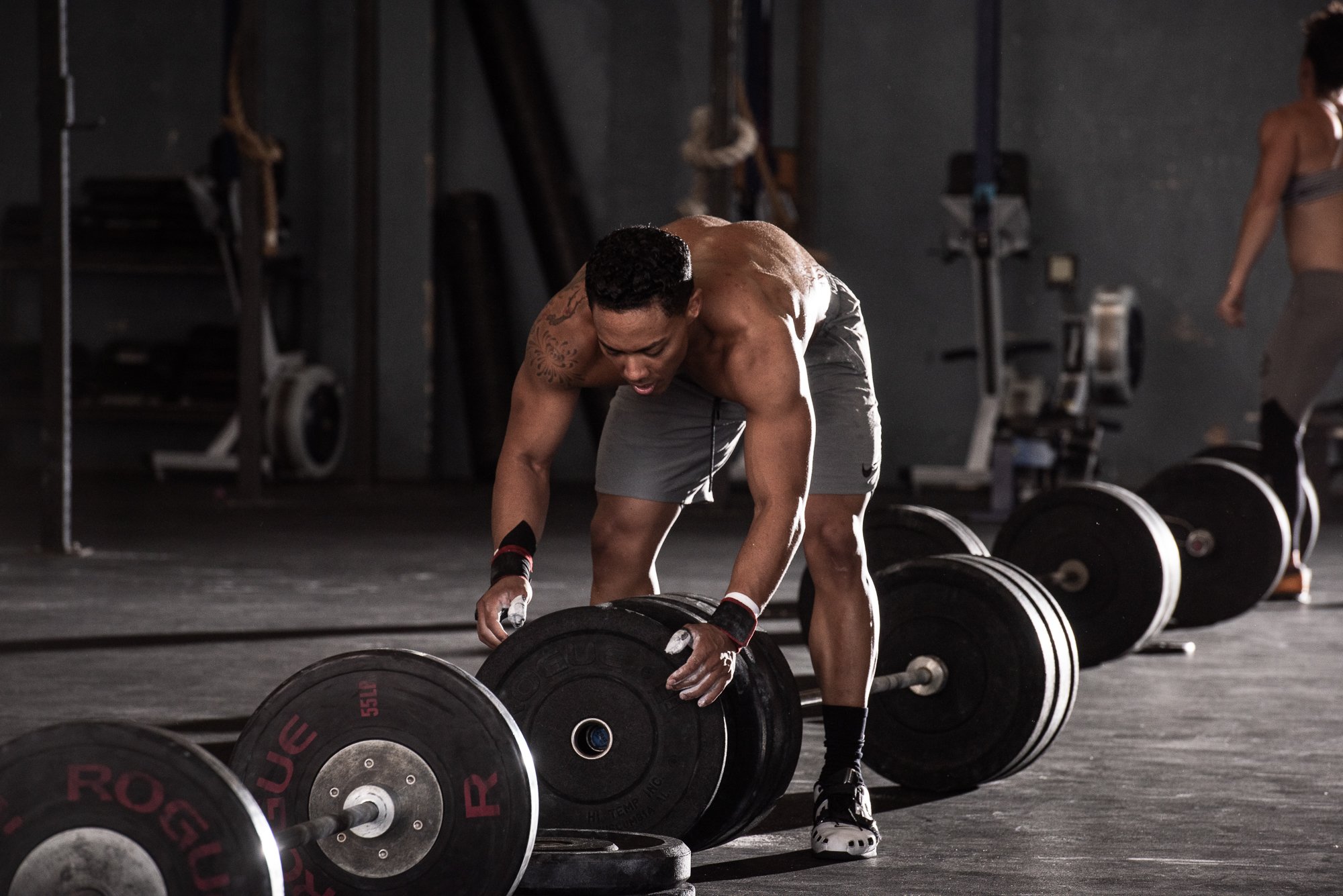 CrossFit athlete preparing a loaded barbell for a strength training movement.