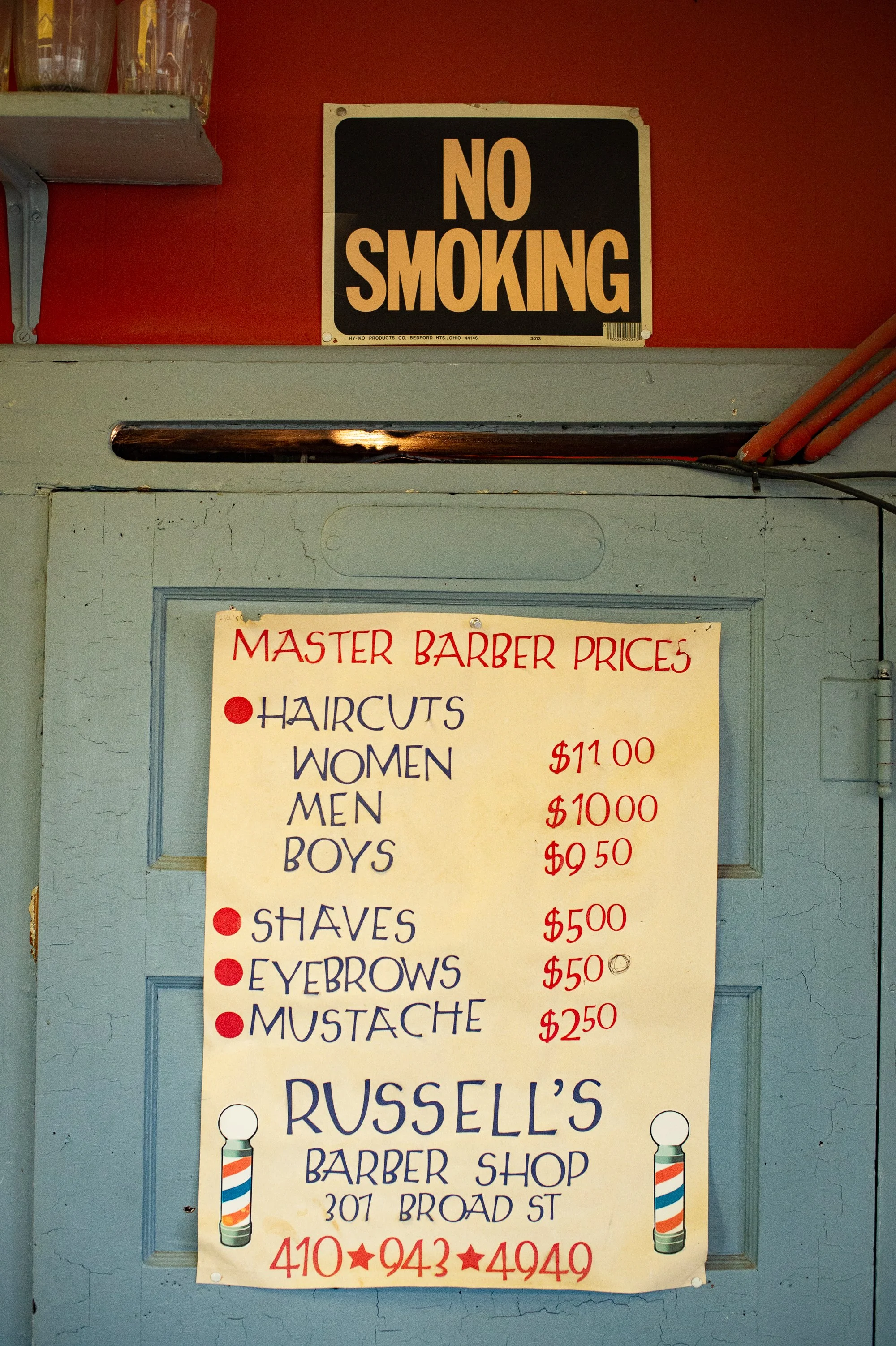 Price list and no smoking sign on the wall inside Russell’s Barbershop in Hurlock Maryland