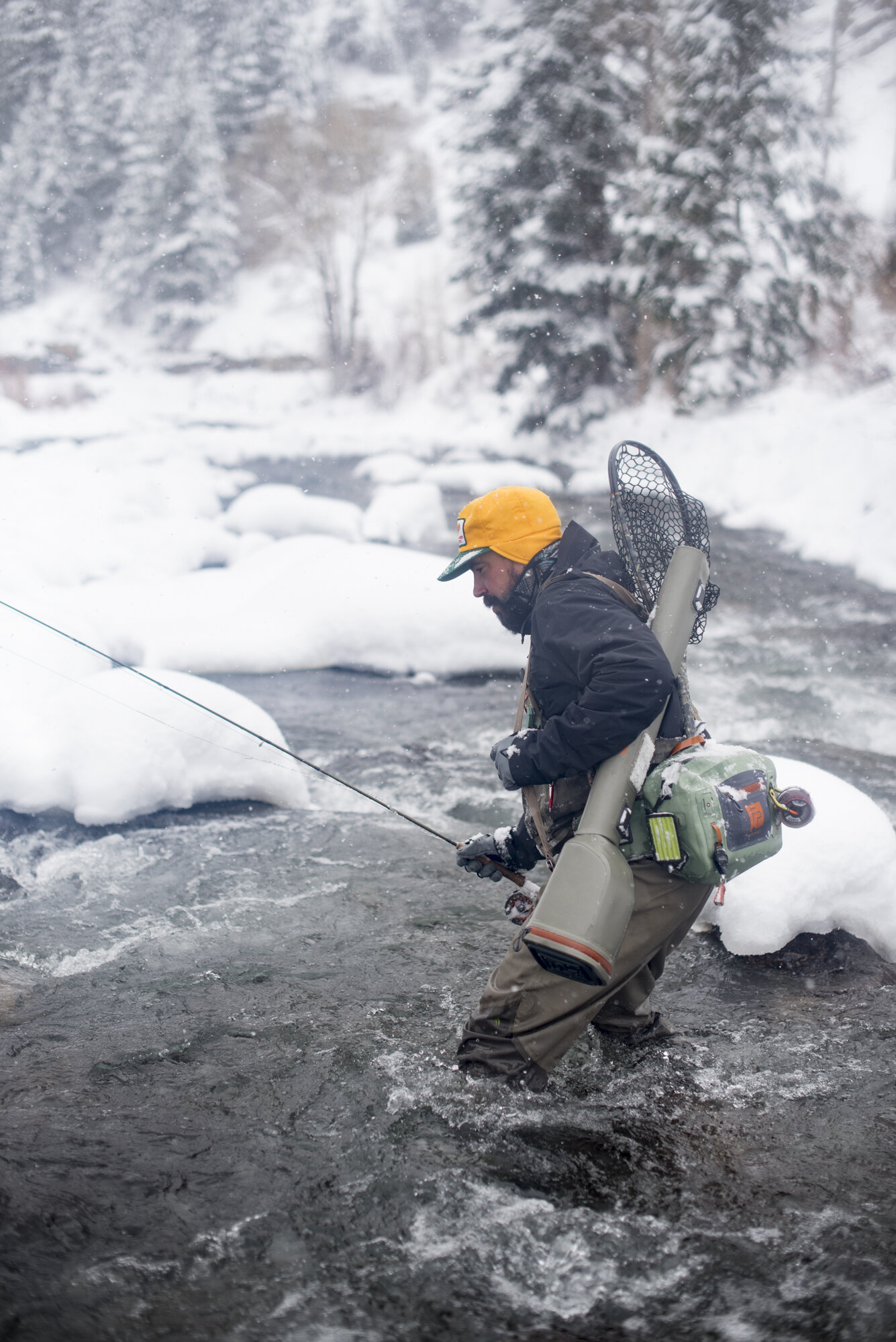  A fly fisherman crossing an icy stream in Colorado.  