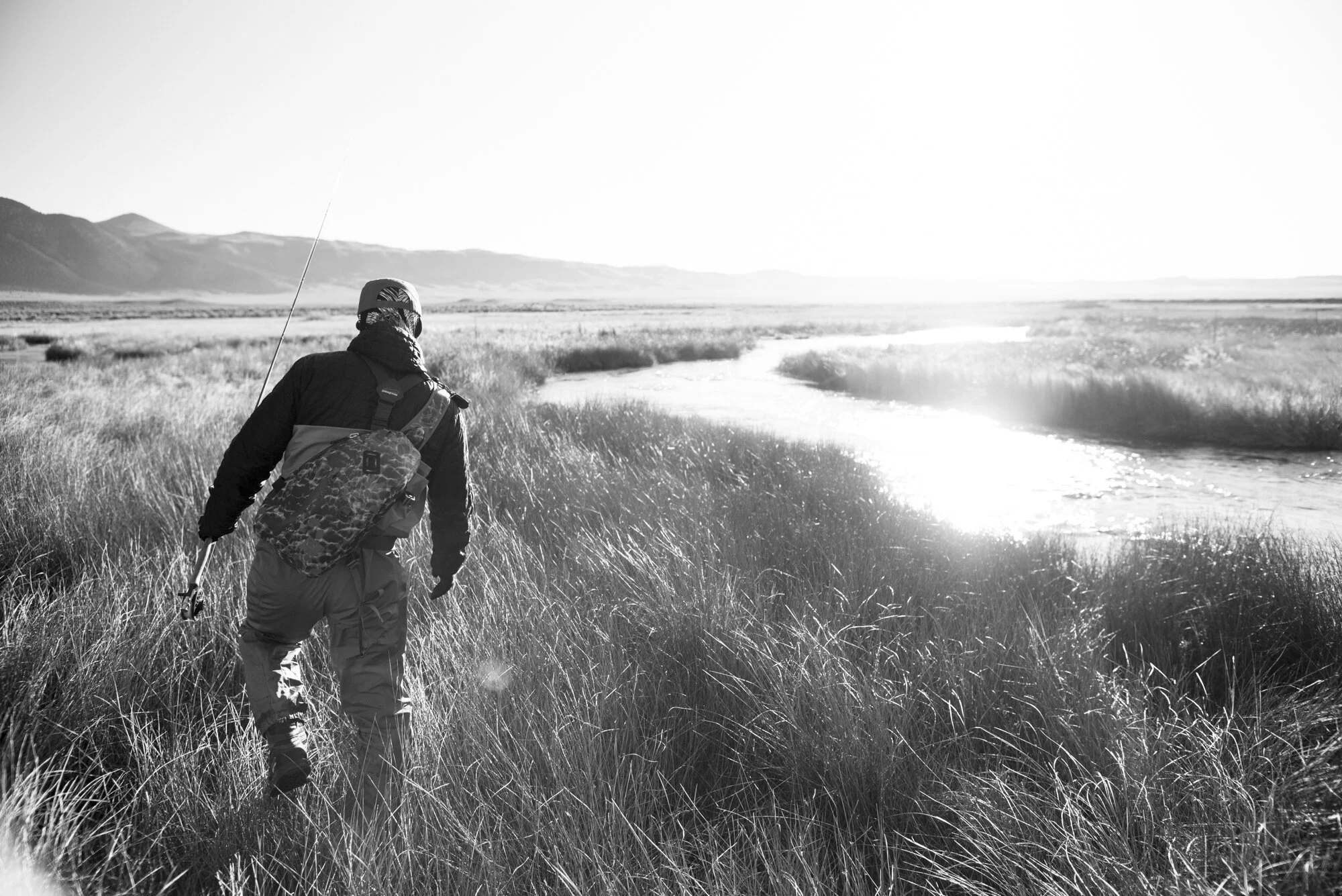   A fly fisherman walks along the Upper Owens River near Mammoth Lakes, California.   Fly fishing photographer, Eastern Sierra, Sierra Nevada Mountains, outdoors, waders, sunrise, adventure 