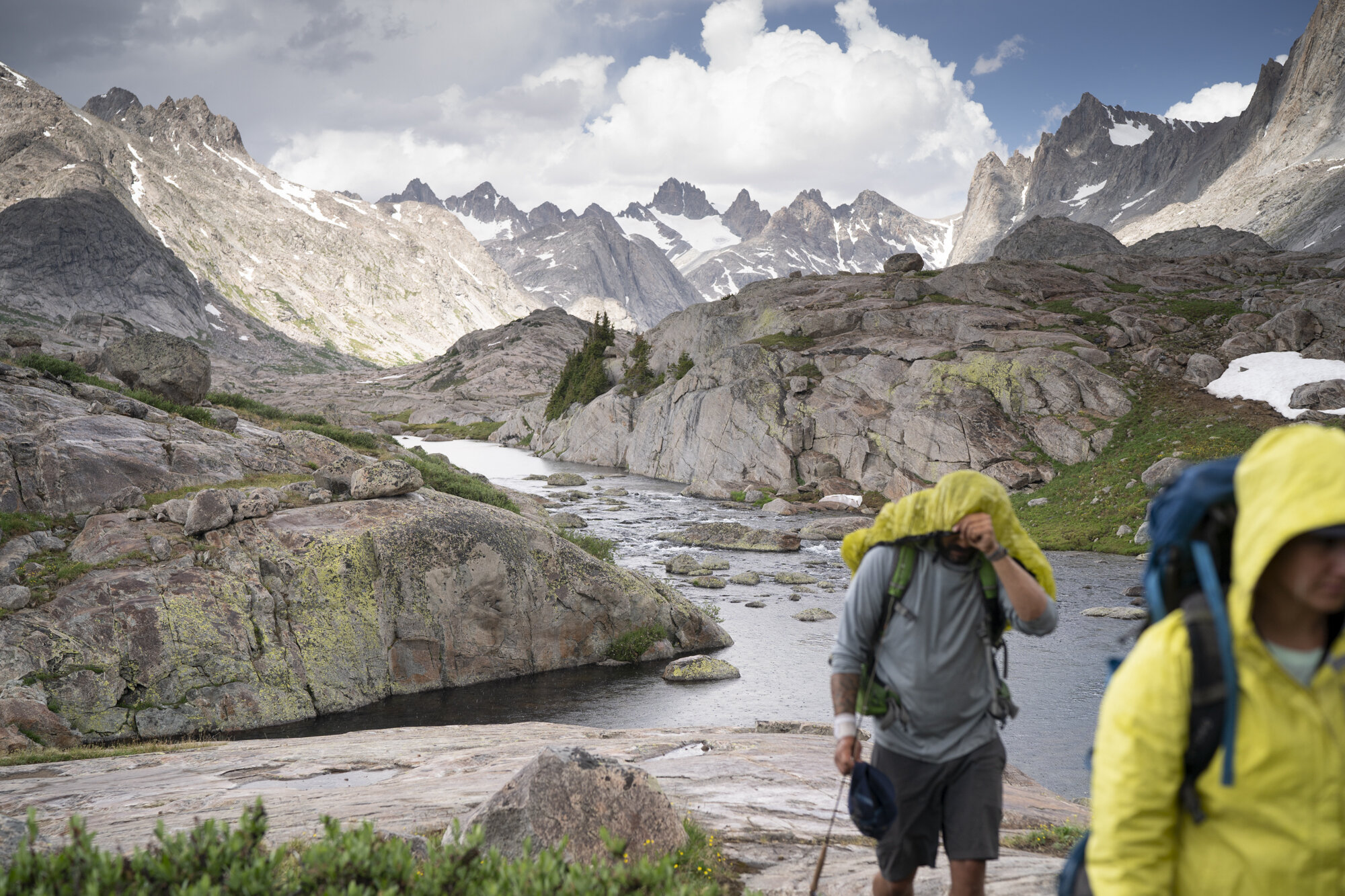  Two hikers protect themselves from rain in the Wind River Range - Wyoming.  