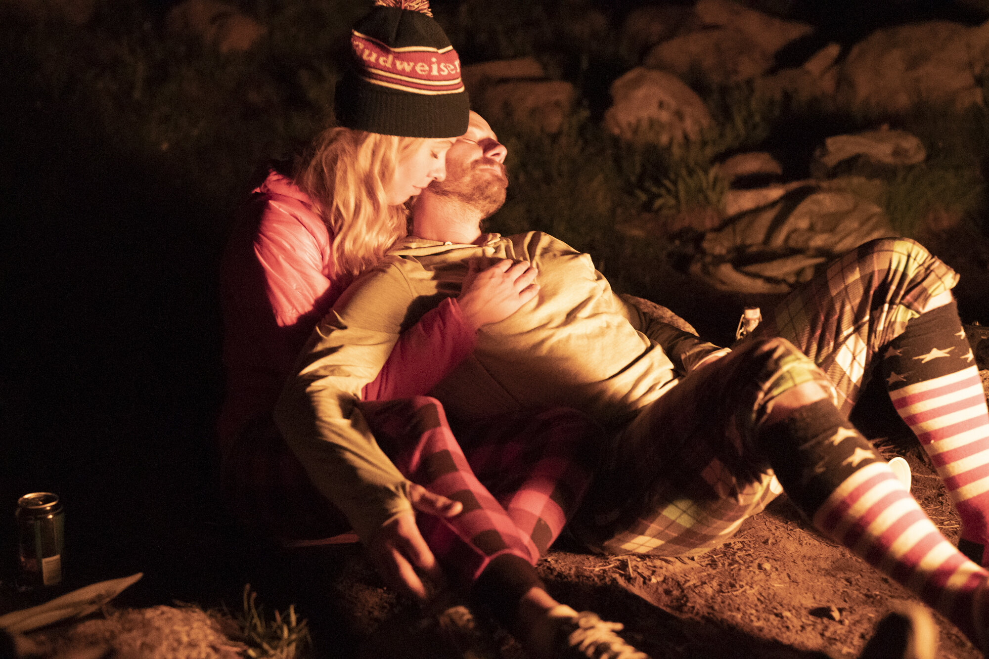  A couple cuddling next to a campfire in the Wind River Range - Wyoming.  