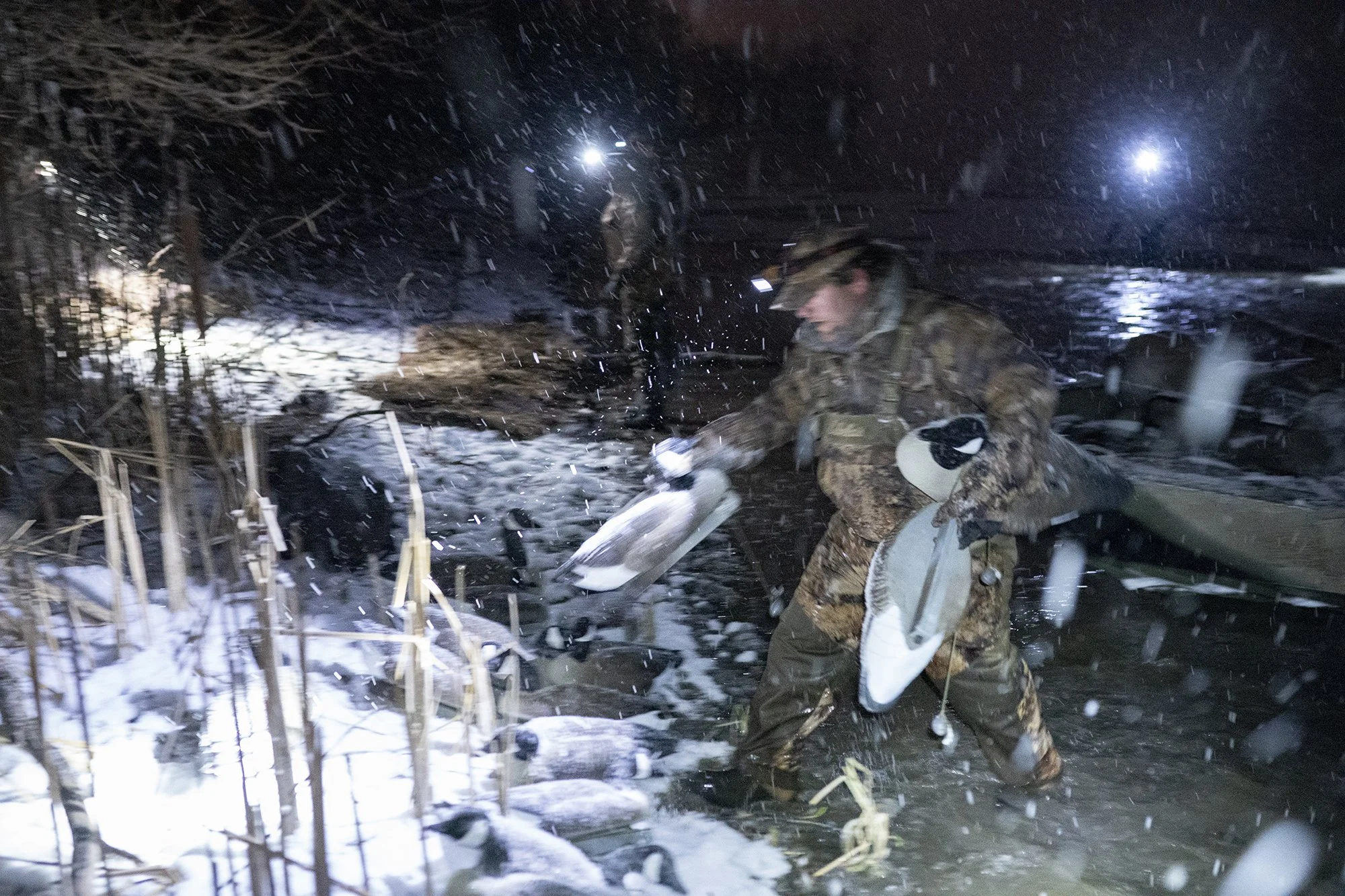  Photograph of duck hunters setting up goose decoys in the dark on a cold and snowy morning in upstate New York - Duck hunting lifestyle - Culture - Waterfowl photography  