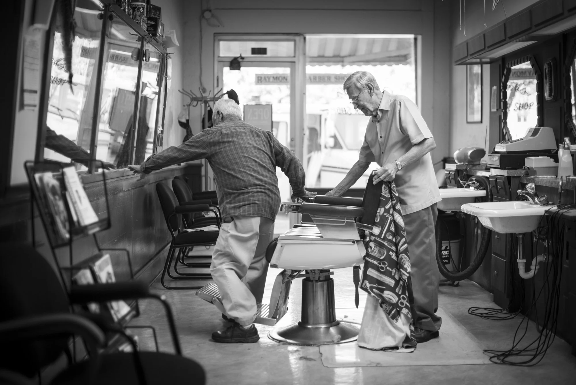  Photo of a customer getting out of the chair at Raymond’s Barbershop - a traditional barbershop in Lockhart, Texas 
