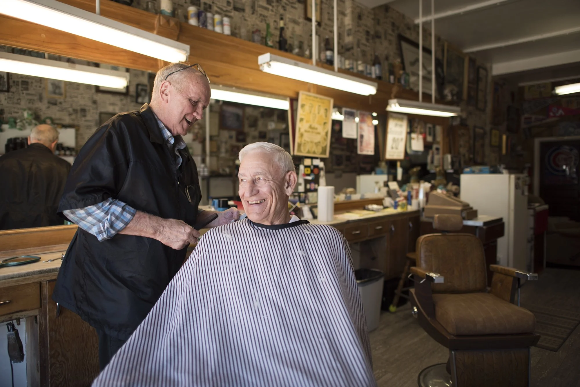  Photo of a customer laughing with his barber at Penrod’s Barbershop - a traditional barbershop in Des Moines, Iowa  