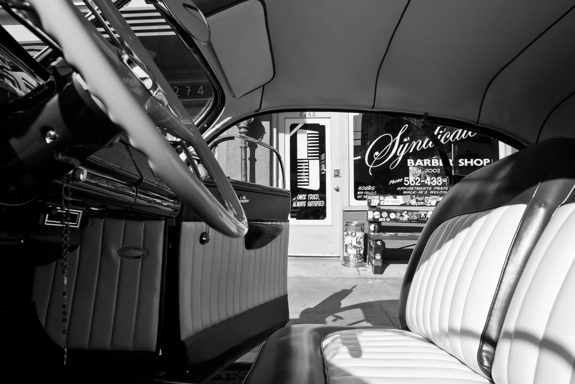  Black and white photograph of a classic car parked in front of Syndicate Barbershop in Long Beach, CA 