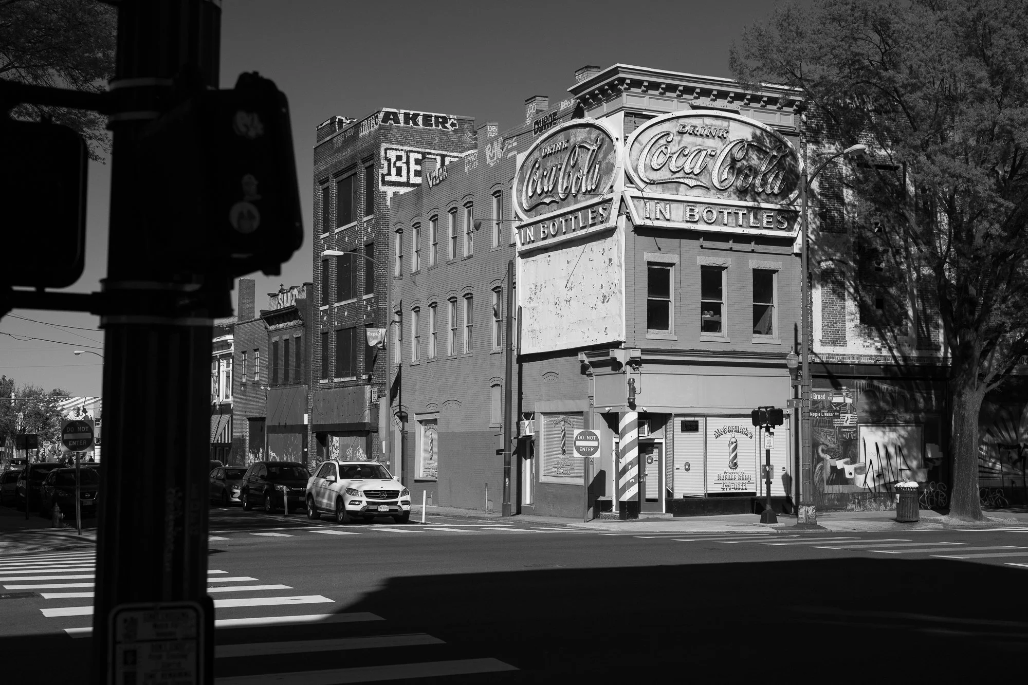  Black and white photograph of the exterior of an old barbershop and vintage Coca Cola sign in Richmond, Virginia 