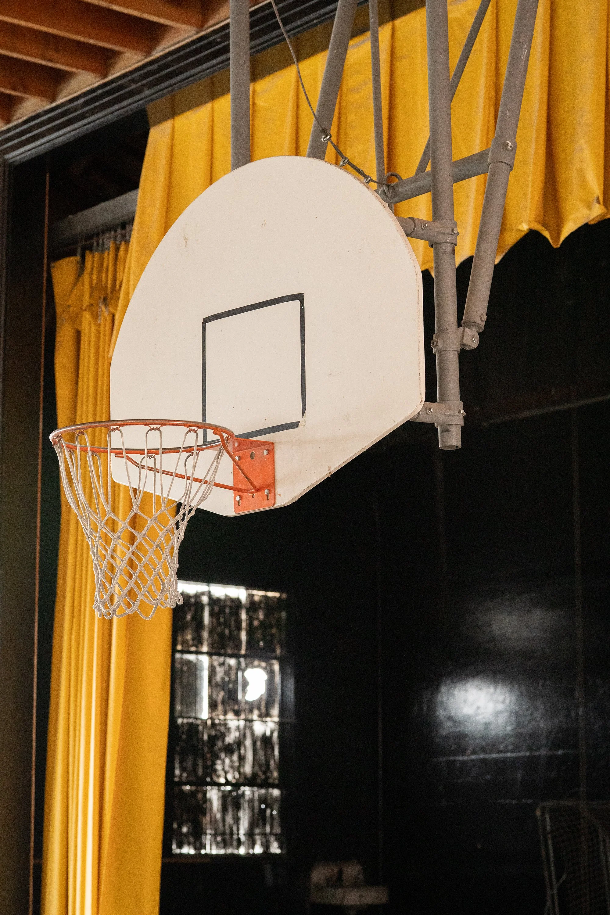  Photograph of an old basketball hoop hanging in an abandoned gymnasium in America    