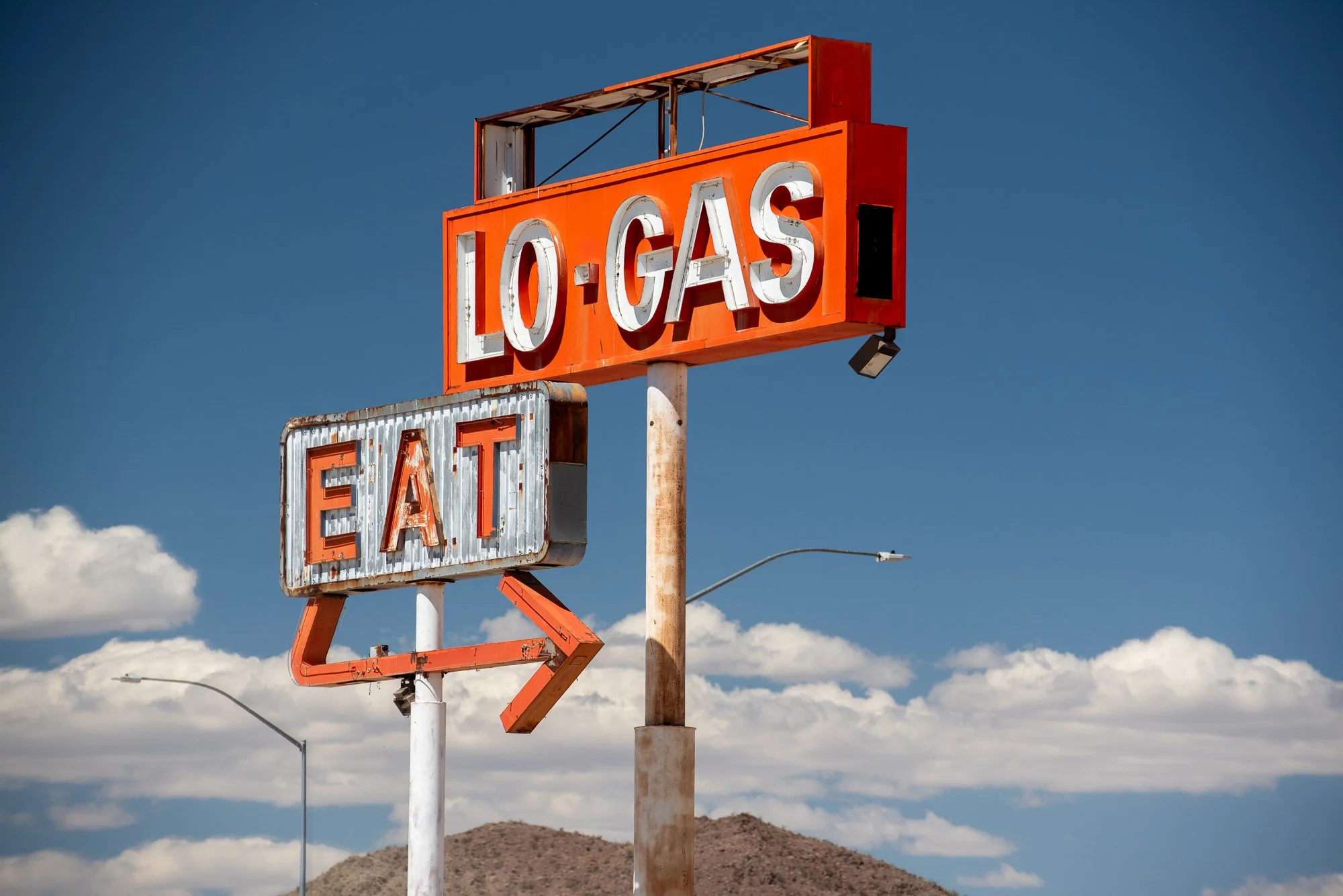 A weathered old vintage lo-gas eat sign in the California desert