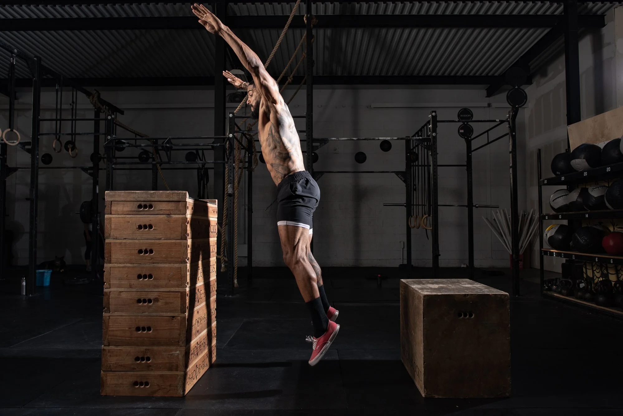 Athlete jumps onto stacked wooden boxes in a Colorado gym during a training session