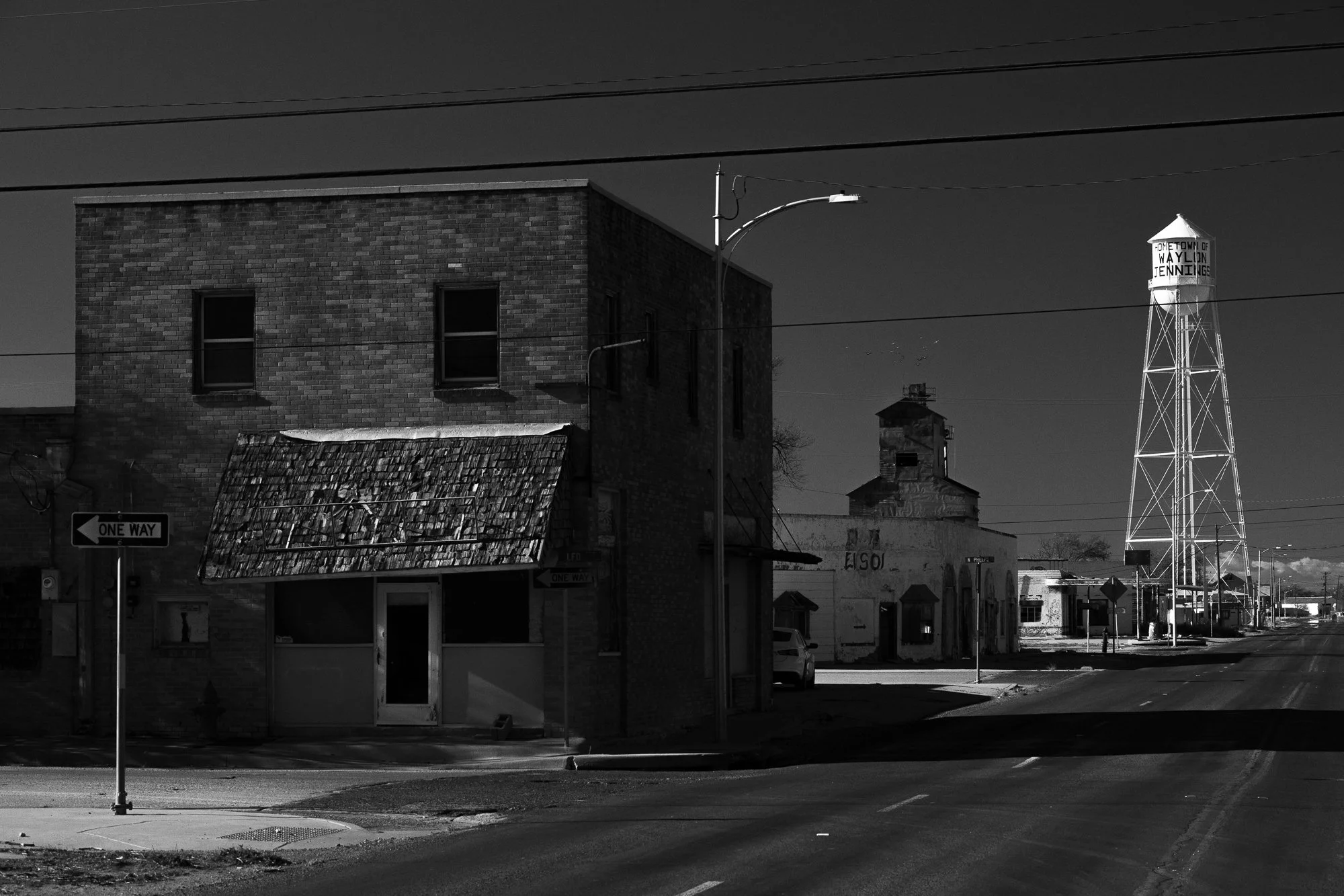 Black and white photograph of Littlefied, Texas with water tower honoring Waylon Jennings