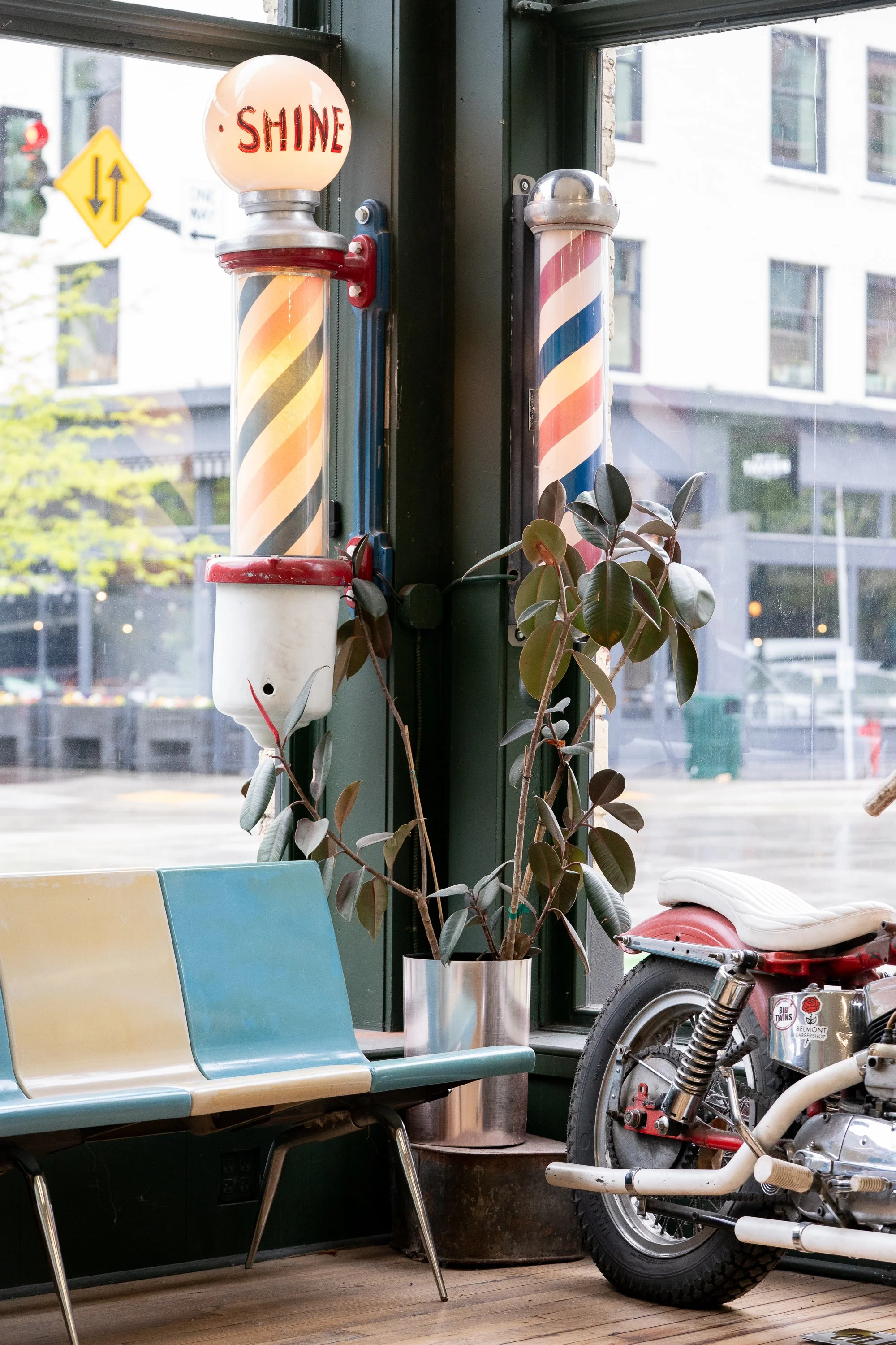 barber pole, bench, plant, and motorcycle inside Belmont Barbershop in Boise Idaho