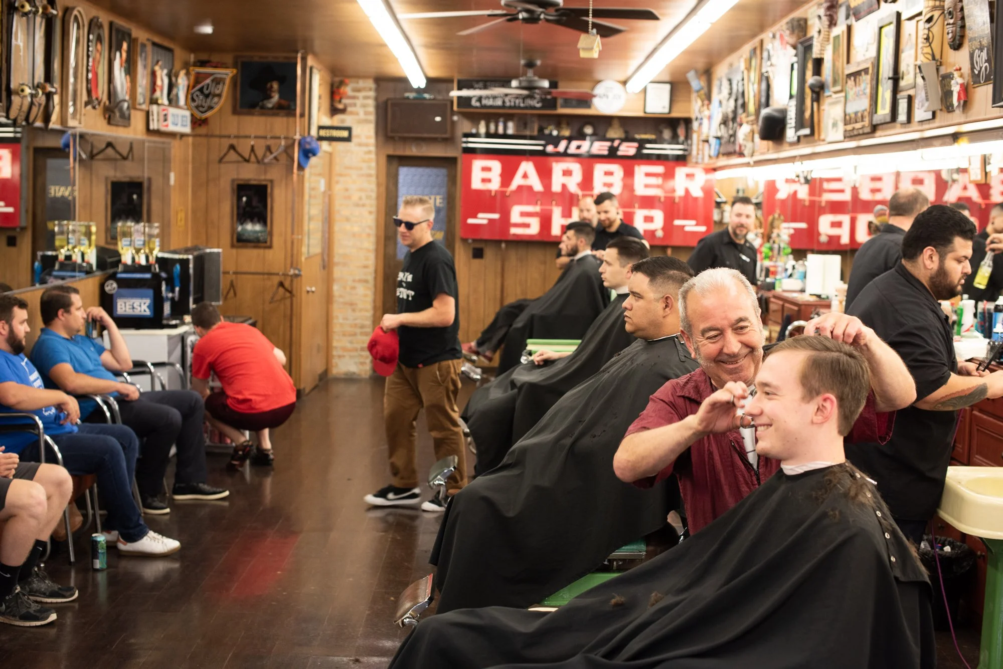 Barbers and customers inside Joe’s Barbershop in Chicago during a busy day