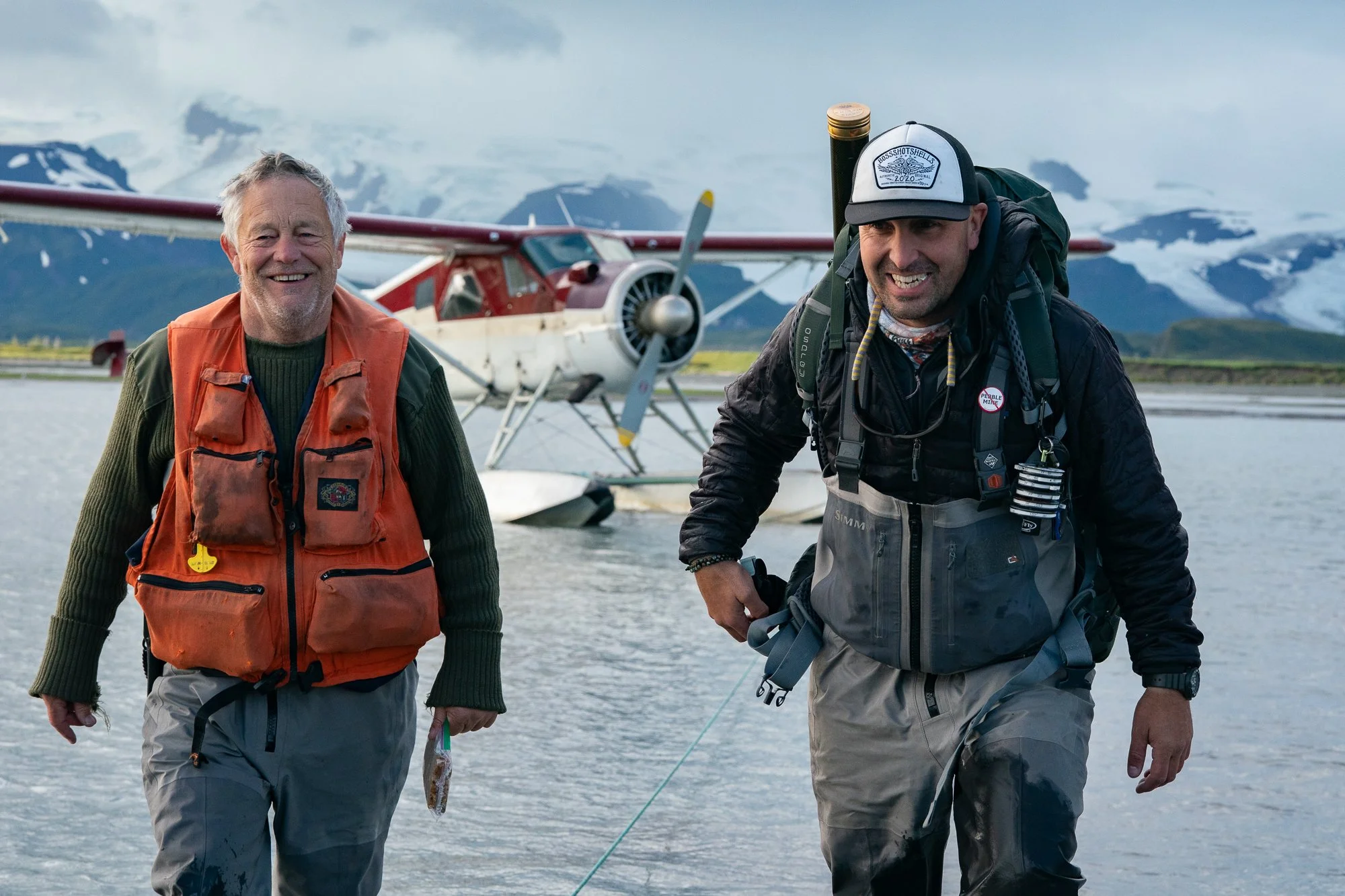Fly fishing guide and angler walking from a float plane in Alaska