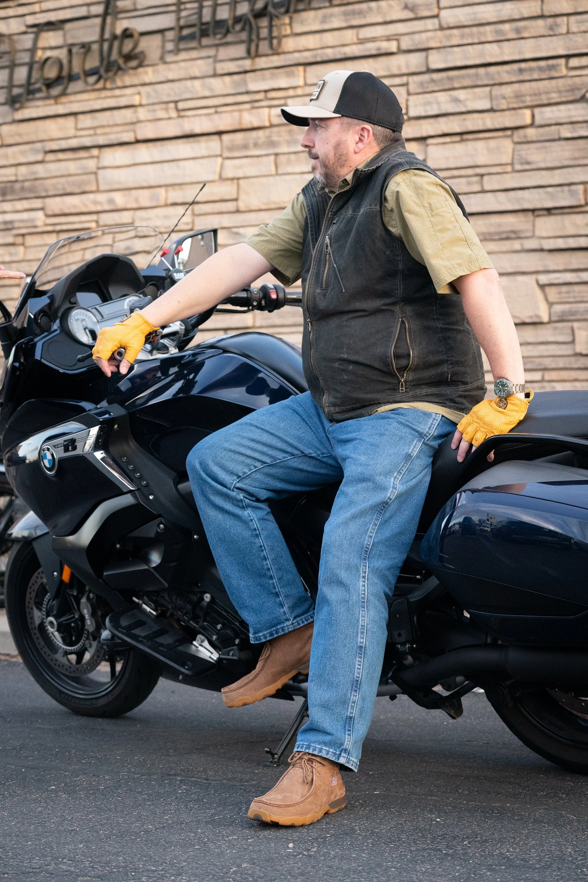 Veteran wearing Twisted X boots seated on a motorcycle outside during a brand campaign